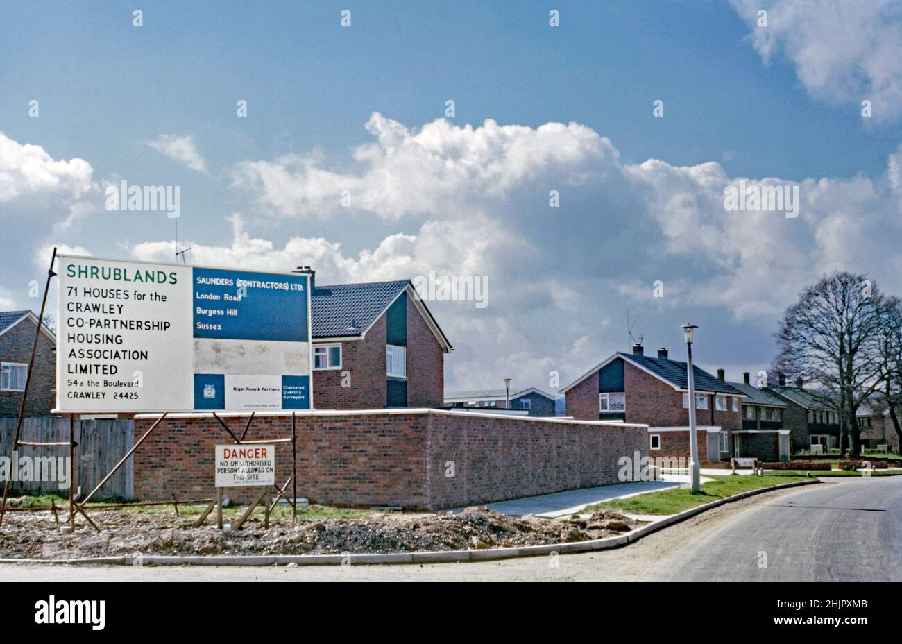 Ein Zeichen für neue Wohnungen in Weald Drive, Furnace Green, Crawley ‘New Town’, West Sussex, England, Großbritannien im Jahr 1966. Das Schild weist darauf hin ‘, dass die kommende „Shrublands“-Entwicklung 71 Häuser für einen Wohnungsverband bauen wird. Das Viertel, südöstlich des Stadtzentrums, war eines von 14 Vororten, die zur Schaffung der ‘neuen Stadt’ nach dem Krieg entwickelt wurden. Nach dem Zweiten Weltkrieg wurden viele Menschen und Arbeitsplätze in die neuen Städte im Südosten Englands verlegt, um diejenigen in Londons armen oder bombardierten Wohnungen zu verlagern, und Crawley war das einzige von ihnen – ein altes Foto aus dem Jahr 1960s. Stockfoto