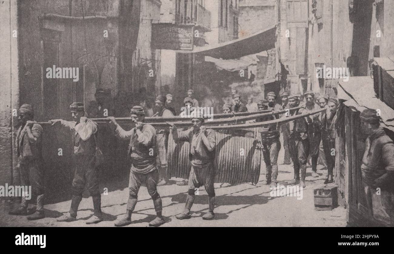 Schwerfällige Prozession durch die gemeinen Straßen Konstantinopels: Acht Männer tragen ein Fass. Türkei. Konstantinopel Istanbul (1923) Stockfoto