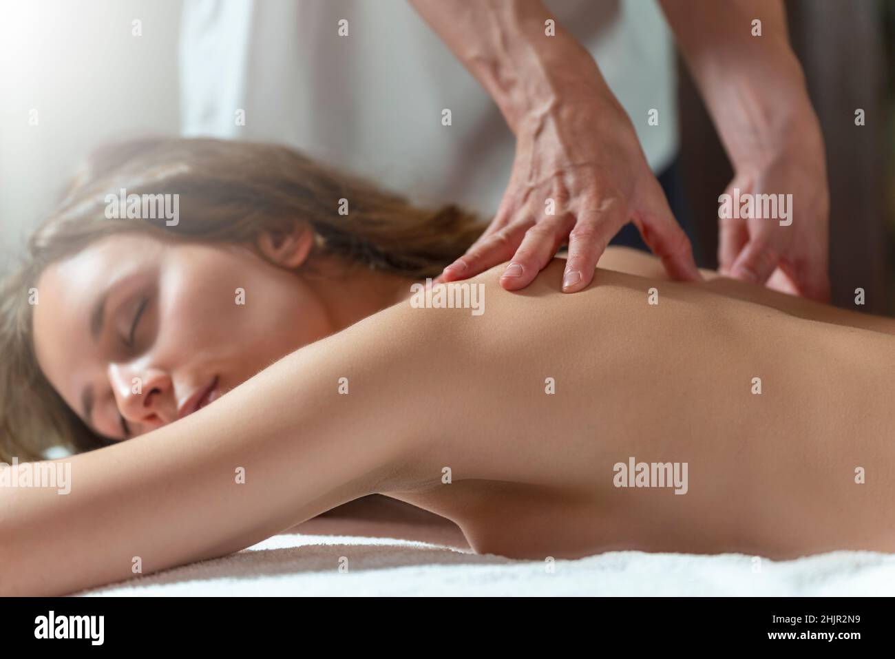 Eine Physiotherapeutin, die einer anderen Frau eine Massage mit Öl gibt Stockfoto
