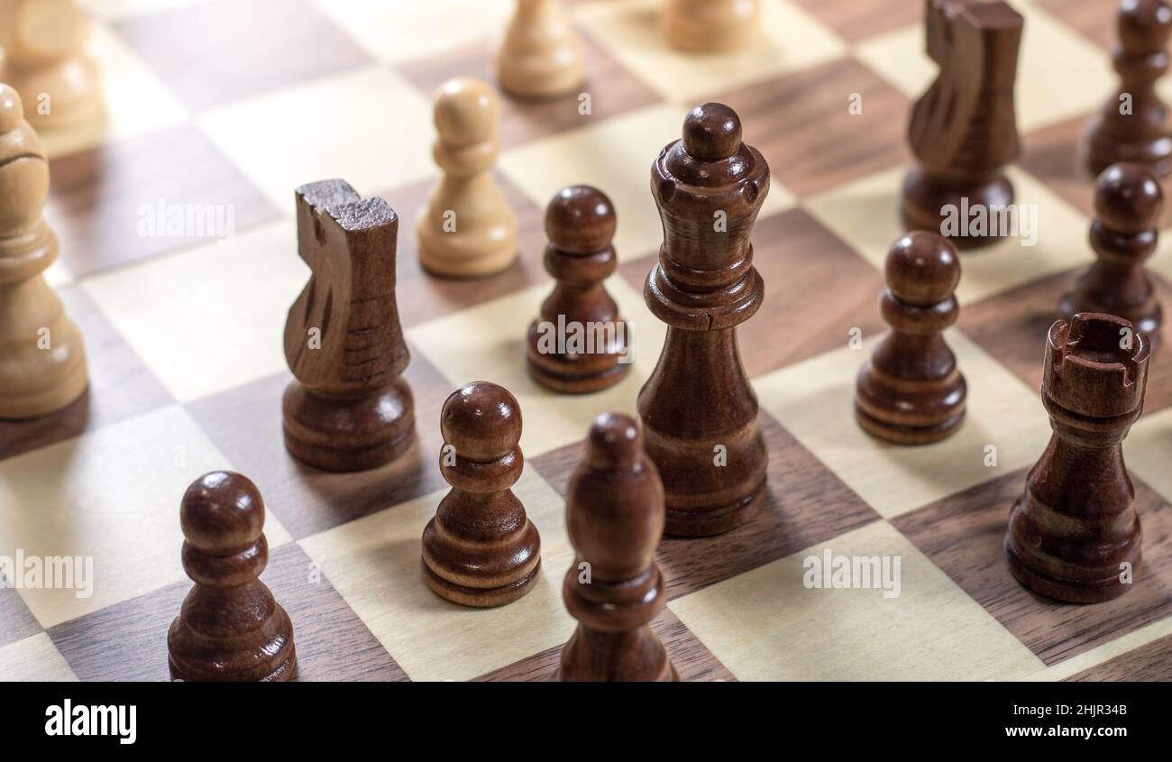 Schachbrett mit Schachspiel wird gespielt. Von oben nach unten. Schwarze Königin und Ritter im Fokus Stockfoto