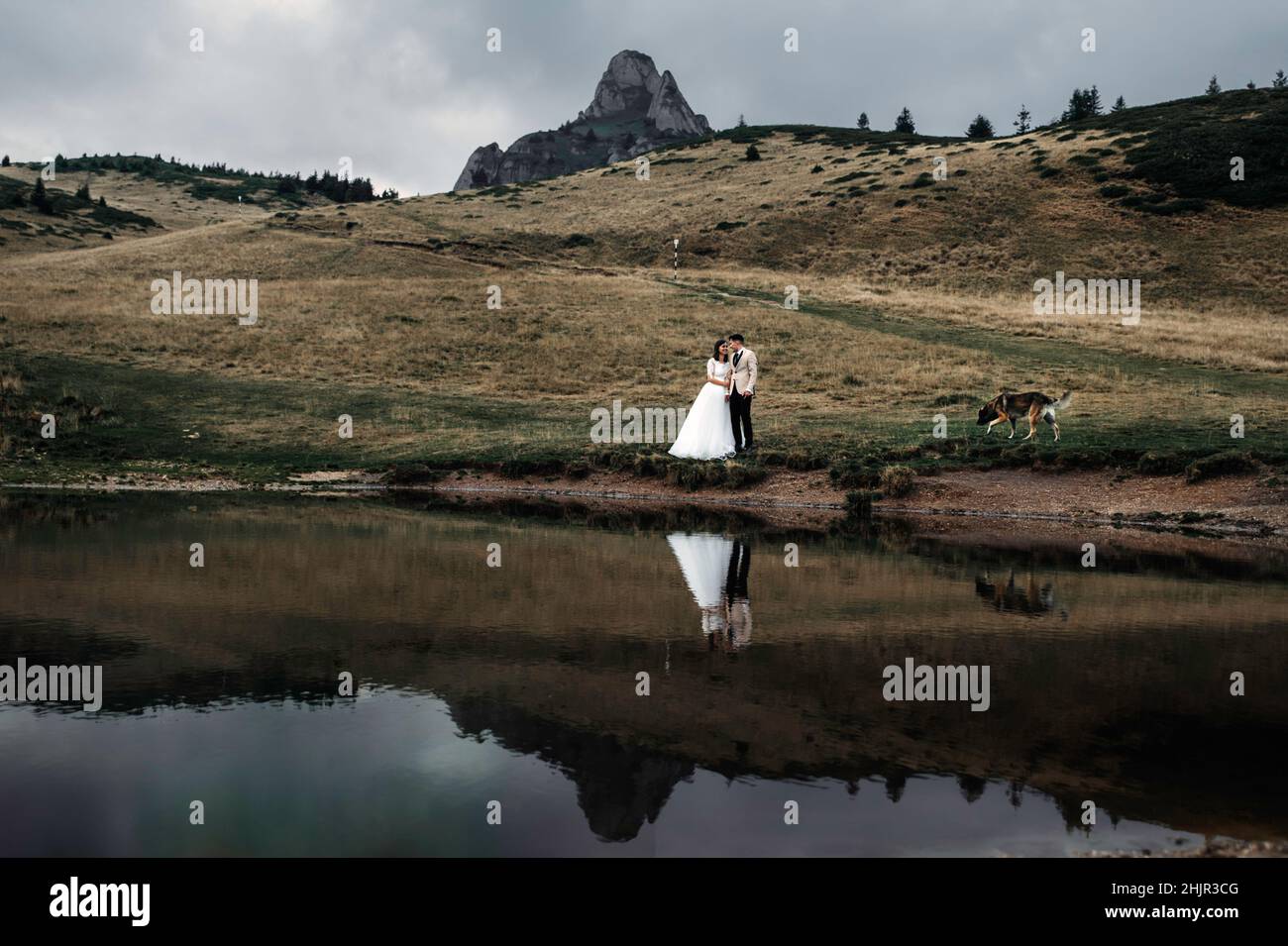 Paar umarmen, während in der Nähe des Sees in der Natur stehen Stockfoto