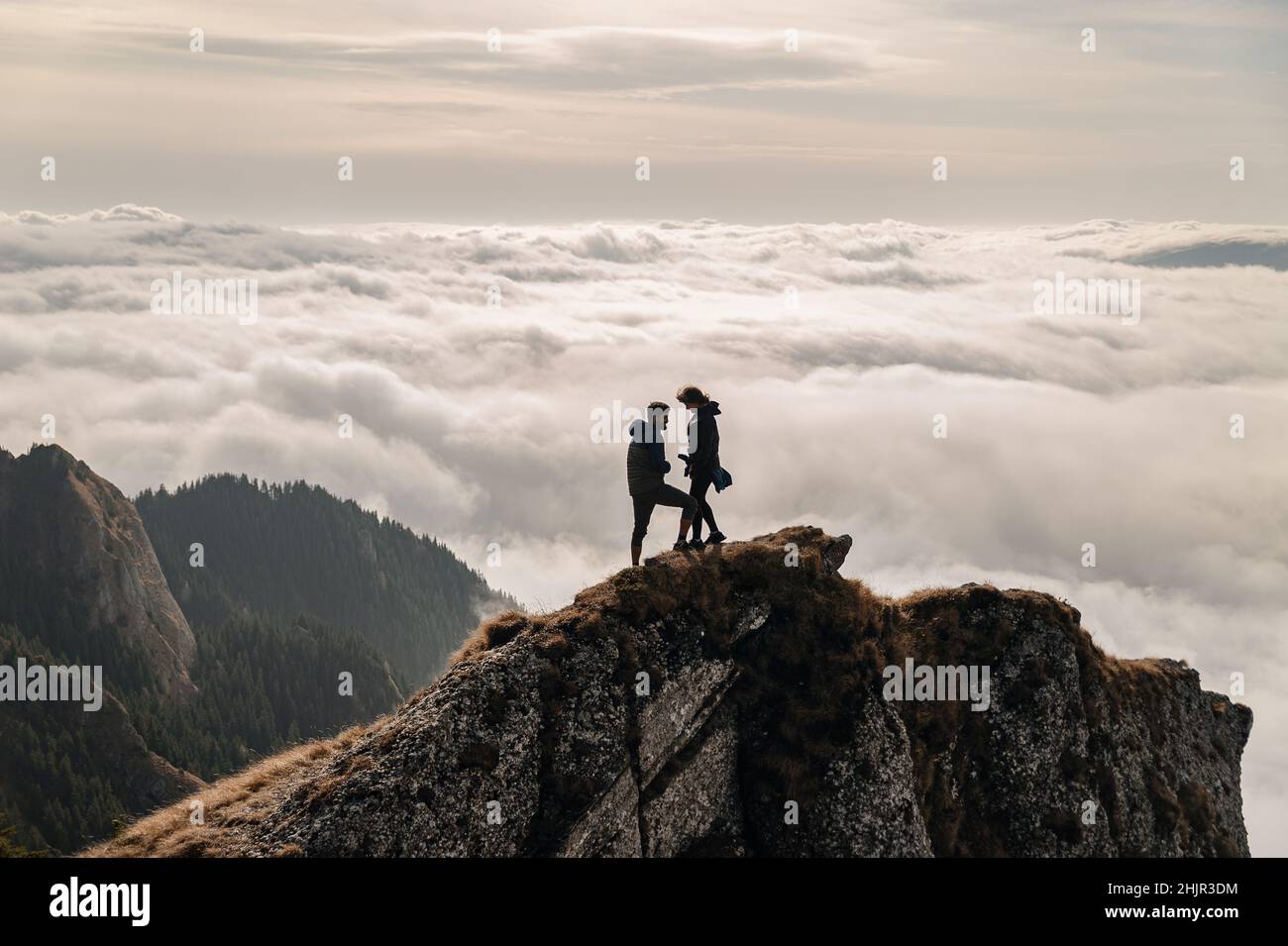 Junges Paar, das den Blick über die Wolken auf dem Berg genießt Stockfoto