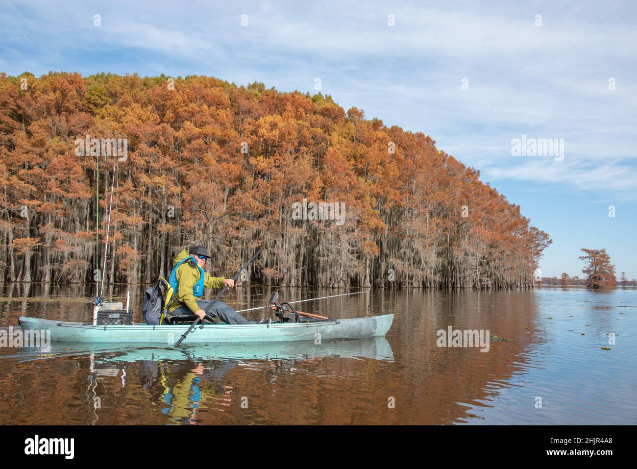 Mann, der im Herbst auf dem See paddelt Stockfoto
