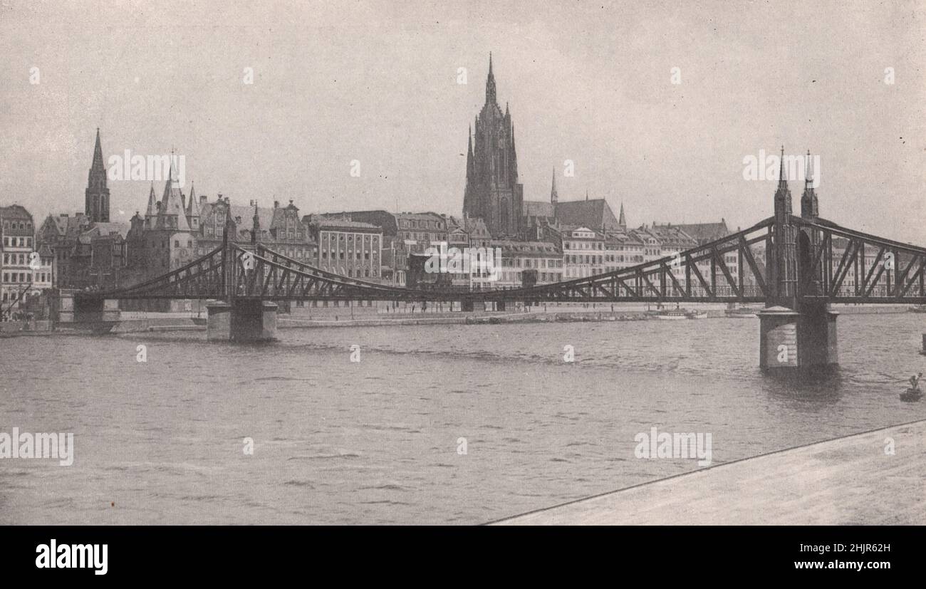 Der über eine Brücke gespalengte Hauptstrom fließt am Westturm der Kathedrale von Frankfort vorbei. Deutschland (1923) Stockfoto