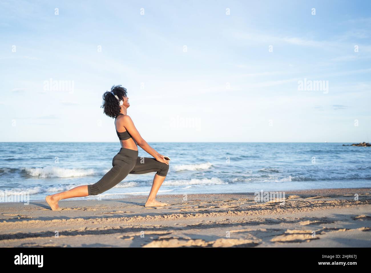 Schwarze Frau praktiziert Yoga am Meer Stockfoto