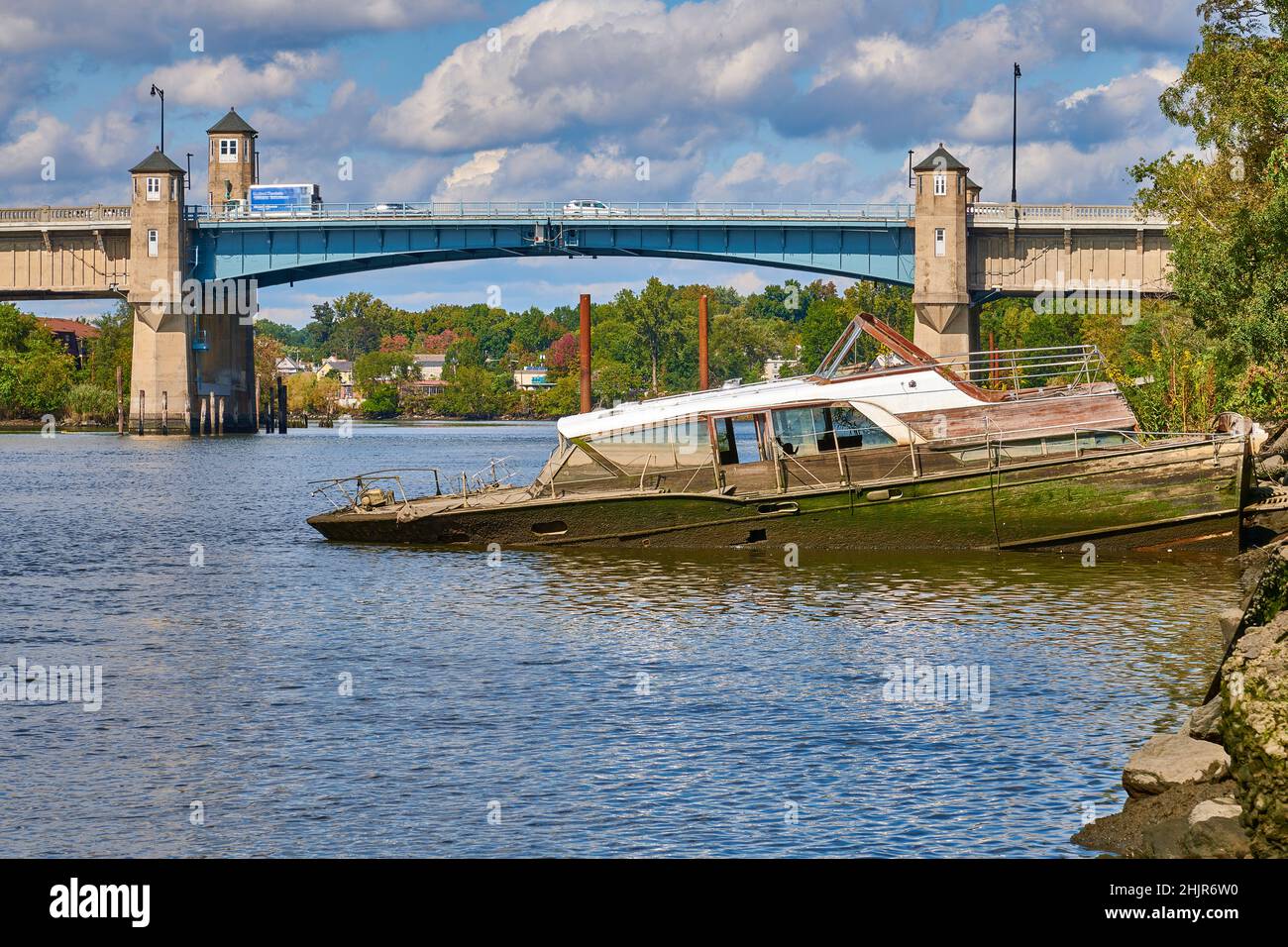 Halb versunkenes Vintage-Boot. Am Hackensack River in New Jersey, USA. Blick Richtung Norden auf die Zugbrücke auf der Winant Avenue, Route 46 East Stockfoto