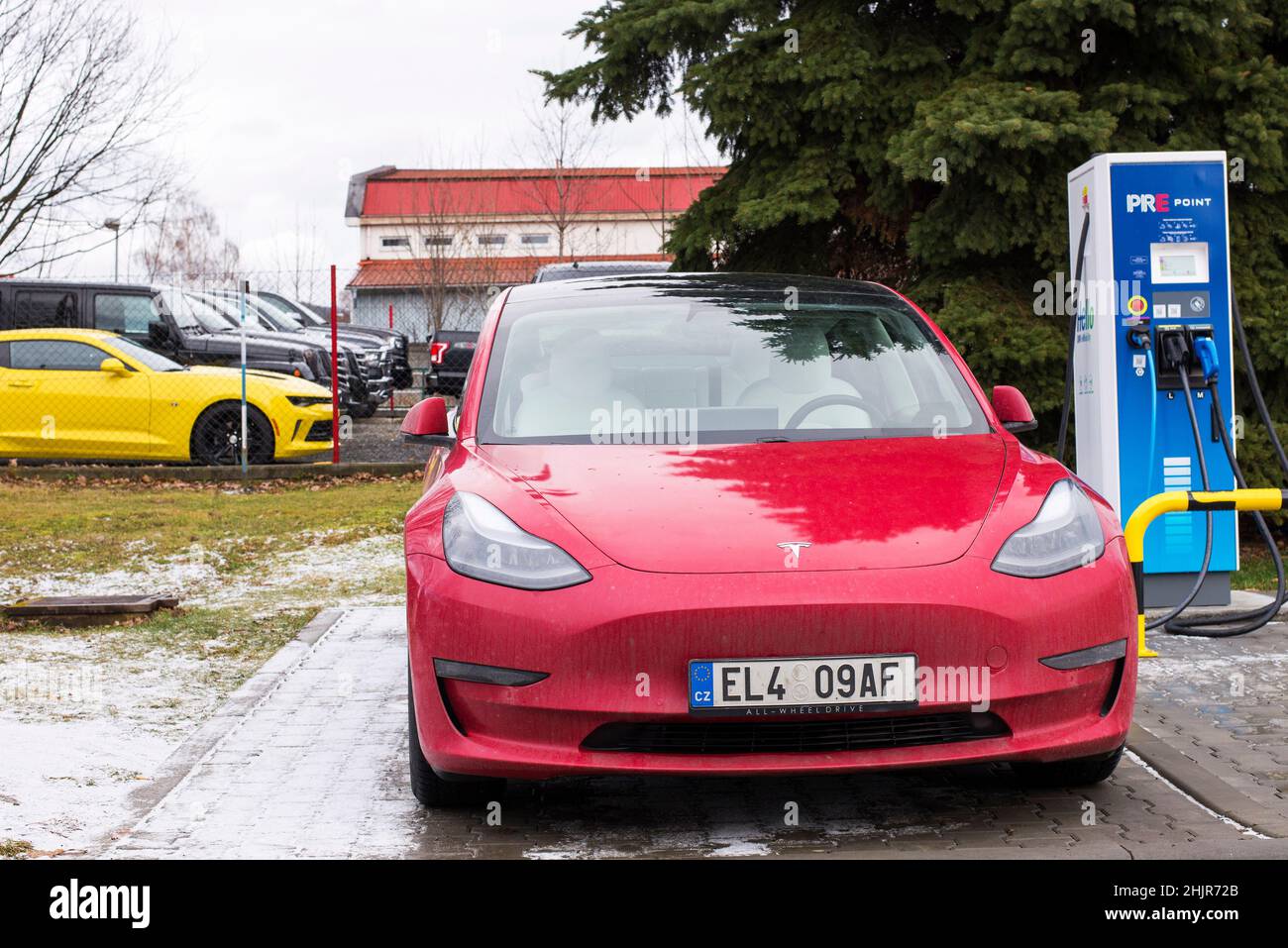 Roznov Tschechische Republik November 20th 2022 - Tesla Model S wird mit einem gelben Muschelwagen im Hintergrund aufgeladen Stockfoto