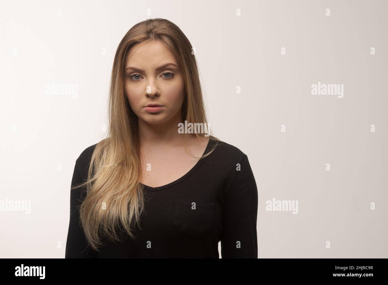 Porträt der traurigen jungen Frau emotional allein auf weißem Hintergrund Stockfoto