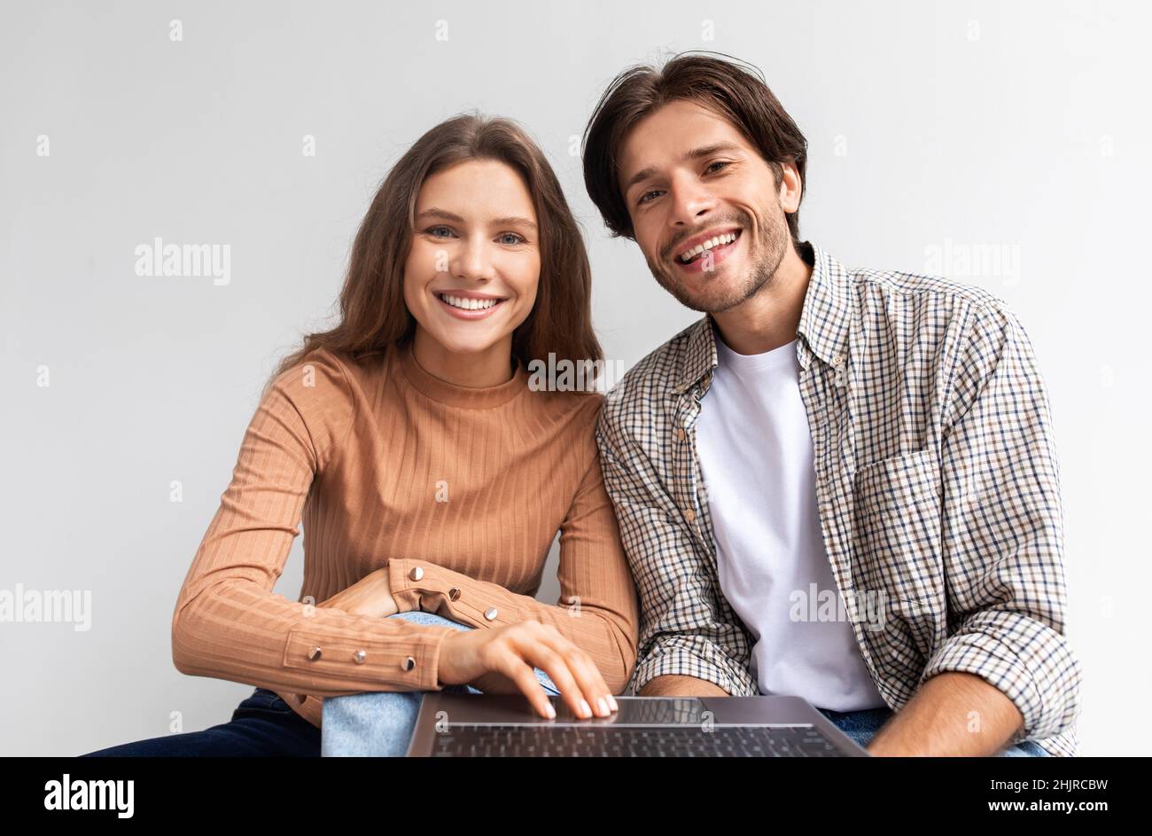 Lächelnde Millennials-europäer blicken auf den Laptop und planen eine Renovierung oder einen Umzug Stockfoto