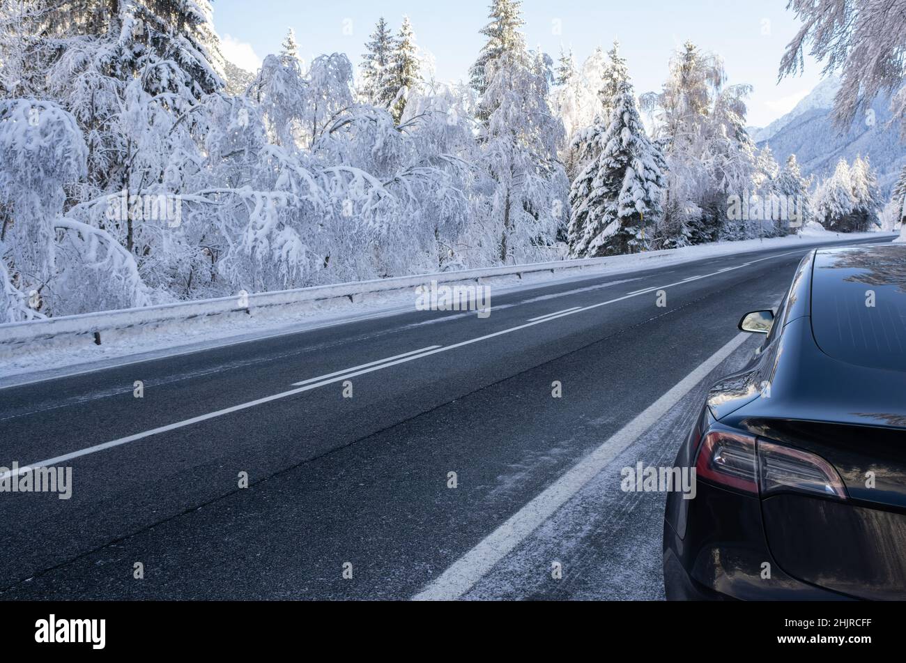 Pontebba, Italien - 7. Januar 2022: Eine statische Aufnahme eines soliden schwarzen Tesla Model 3 Zweimotor-langbereich-awd mit getönten Fenstern und Aero-Rädern mit einem s Stockfoto