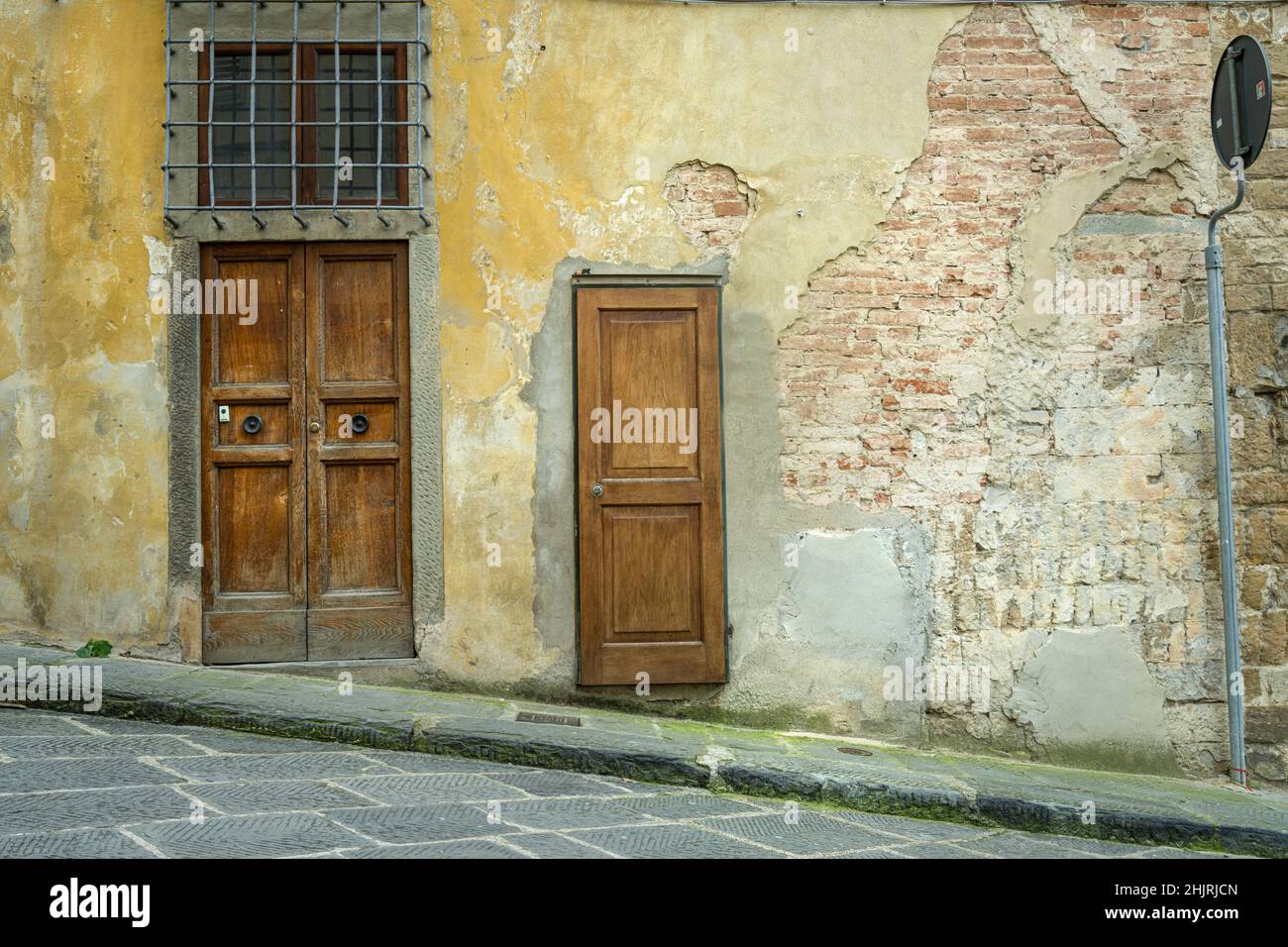 Florenz, Italien. Januar 2022. Die Eingangstüren zu einem alten Gebäude an einer bergauf führenden Straße im historischen Zentrum der Stadt Stockfoto