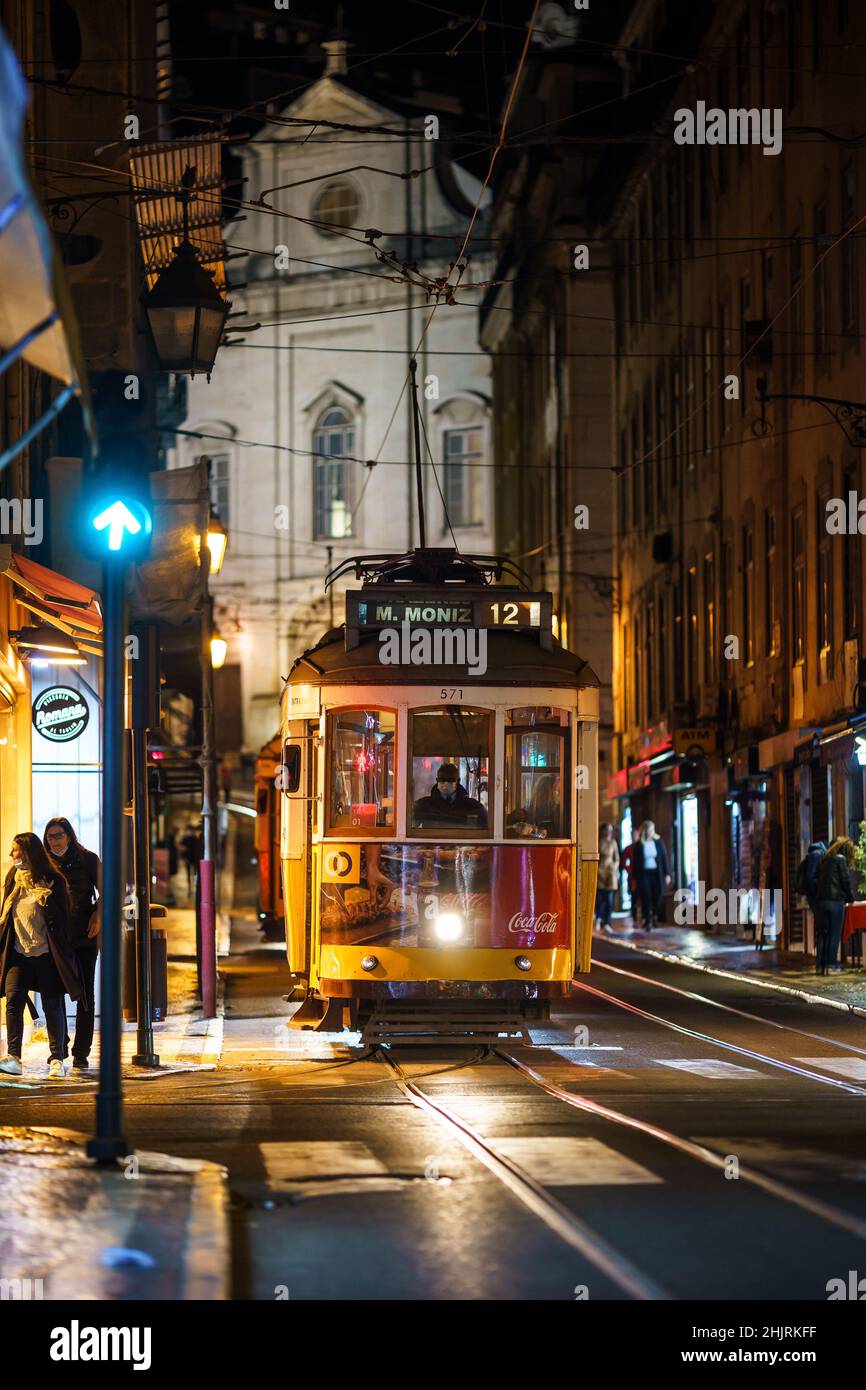 Lissabon, Portugal - 18 2021. November: Eine ikonische Straßenbahn wartet nachts an einer Ampel im historischen Zentrum von Lissabon. Stockfoto
