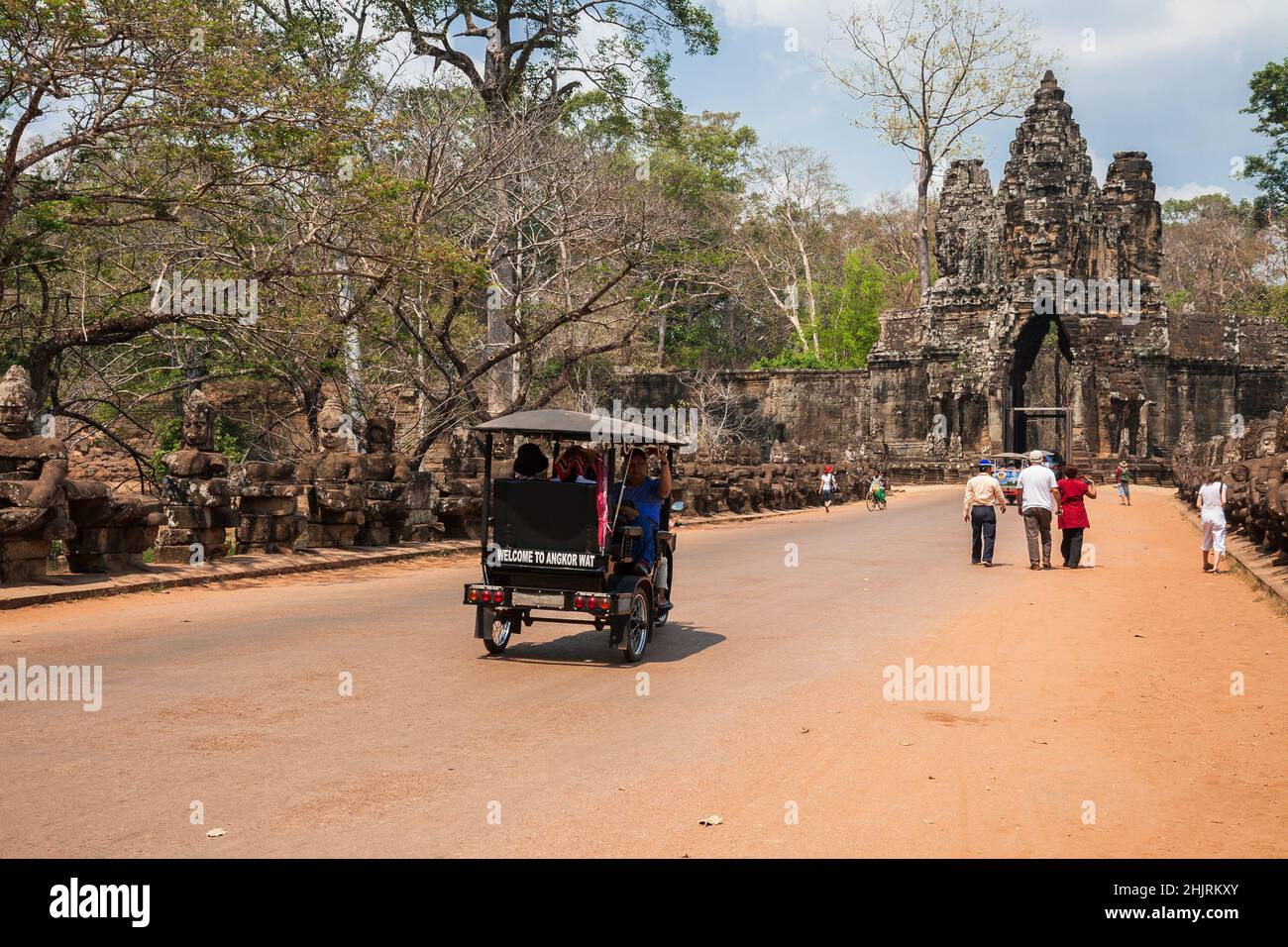 Siem Reap, Kambodscha - Februar 2013: Touristen auf Auto-Rikschas und zu Fuß besuchen den Tempelkomplex von Angkor Thom durch das Südtor Stockfoto