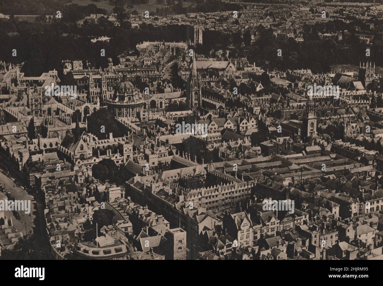 Oxford. Der Magdalen-Turm, in einer Baumgruppe am Cherwell, beendet den geschwungenen Schwung des „High“; links ist die Broad Street (1923) Stockfoto