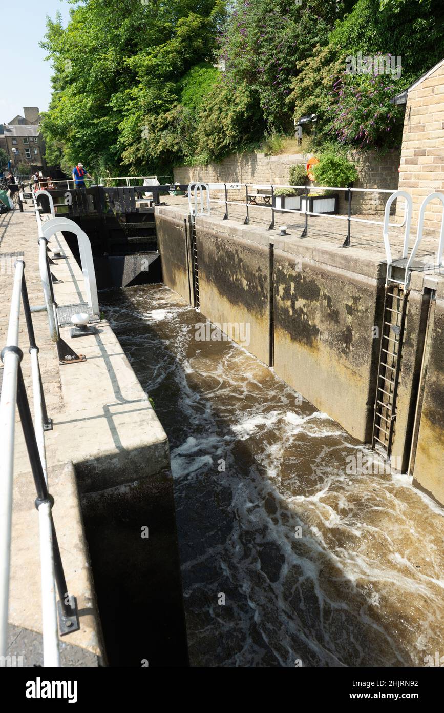 Sommeransicht der Kammer der TUEL Lane Lock auf dem Rochdale Canal, die mit Wasser gefüllt ist, damit ein Boot hineingehen kann Stockfoto