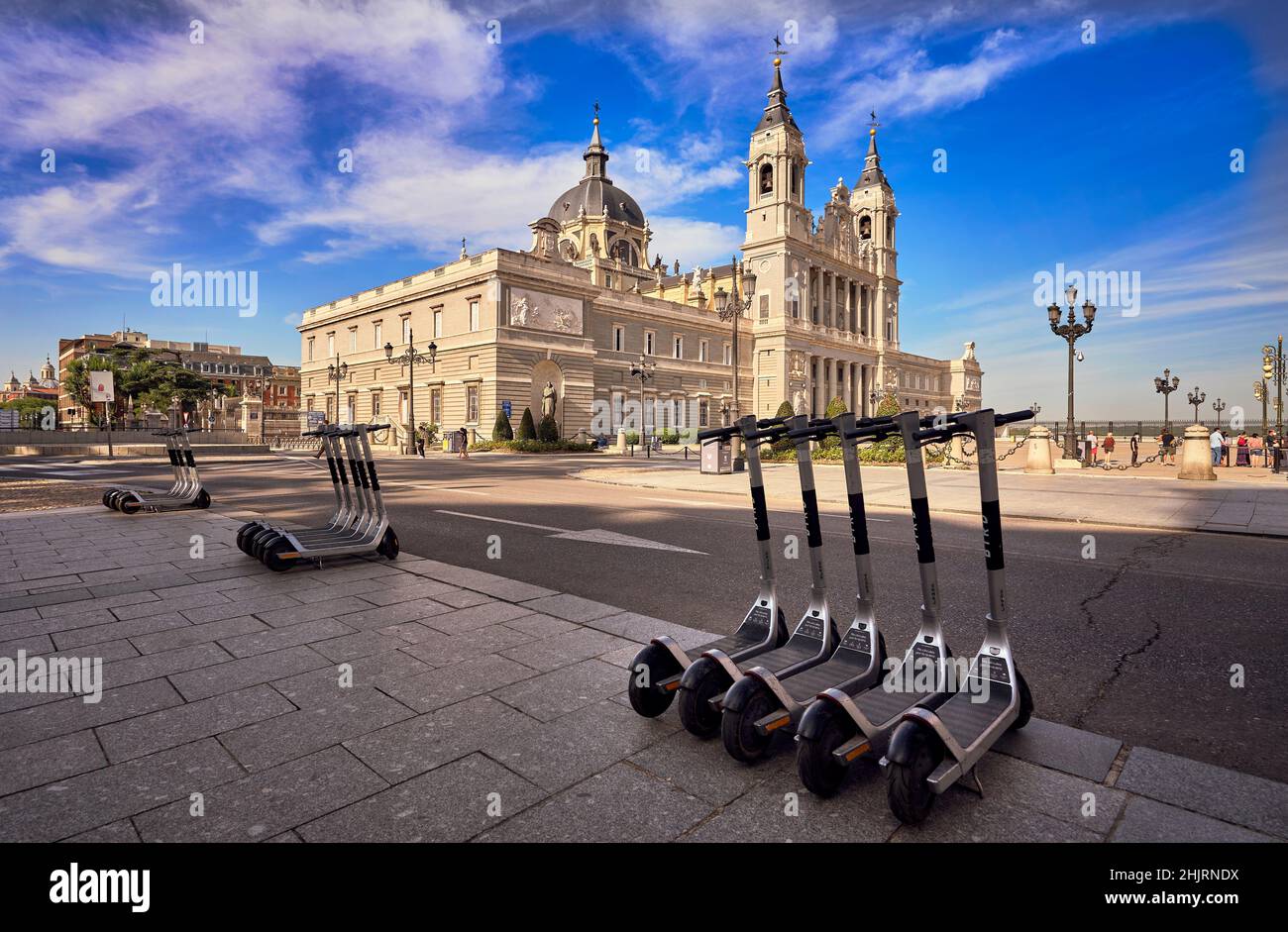 Elektroroller bei der Kathedrale von Almudena geparkt. Madrid, Spanien. Roller sind zu einer gemeinsamen Lösung für die urbane Mobilität im Stadtzentrum geworden. Stockfoto