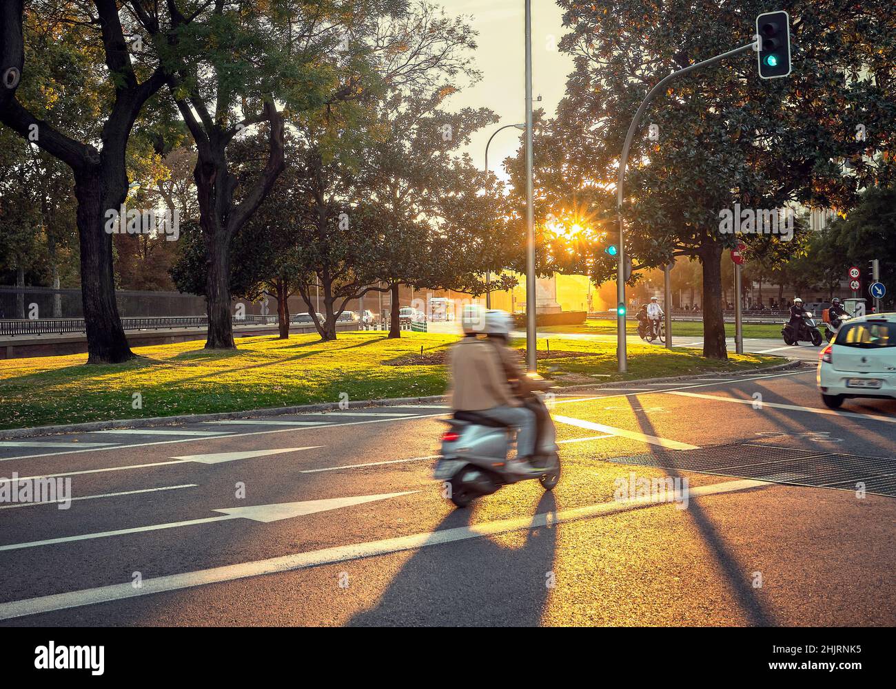 Motorroller Motorrad vorbei an O'Donell Straße neben dem Retiro Park bei Sonnenuntergang. Madrid. Spanien. Stockfoto