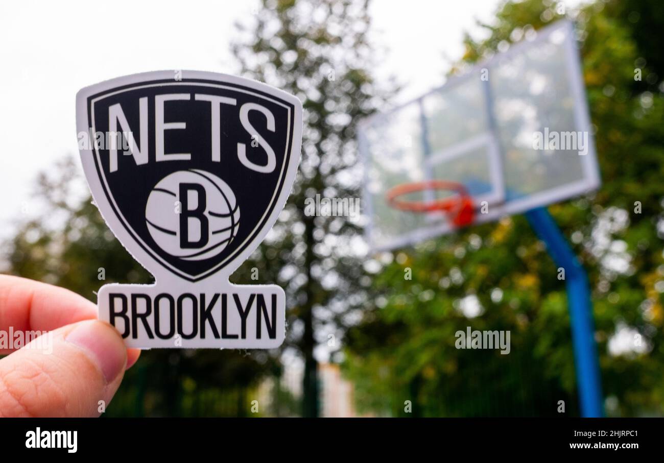 15. September 2021, New York, USA, Ein Mann hält das Logo des Brooklyn Nets Basketballclubs in der Hand auf dem Sportplatz. Stockfoto