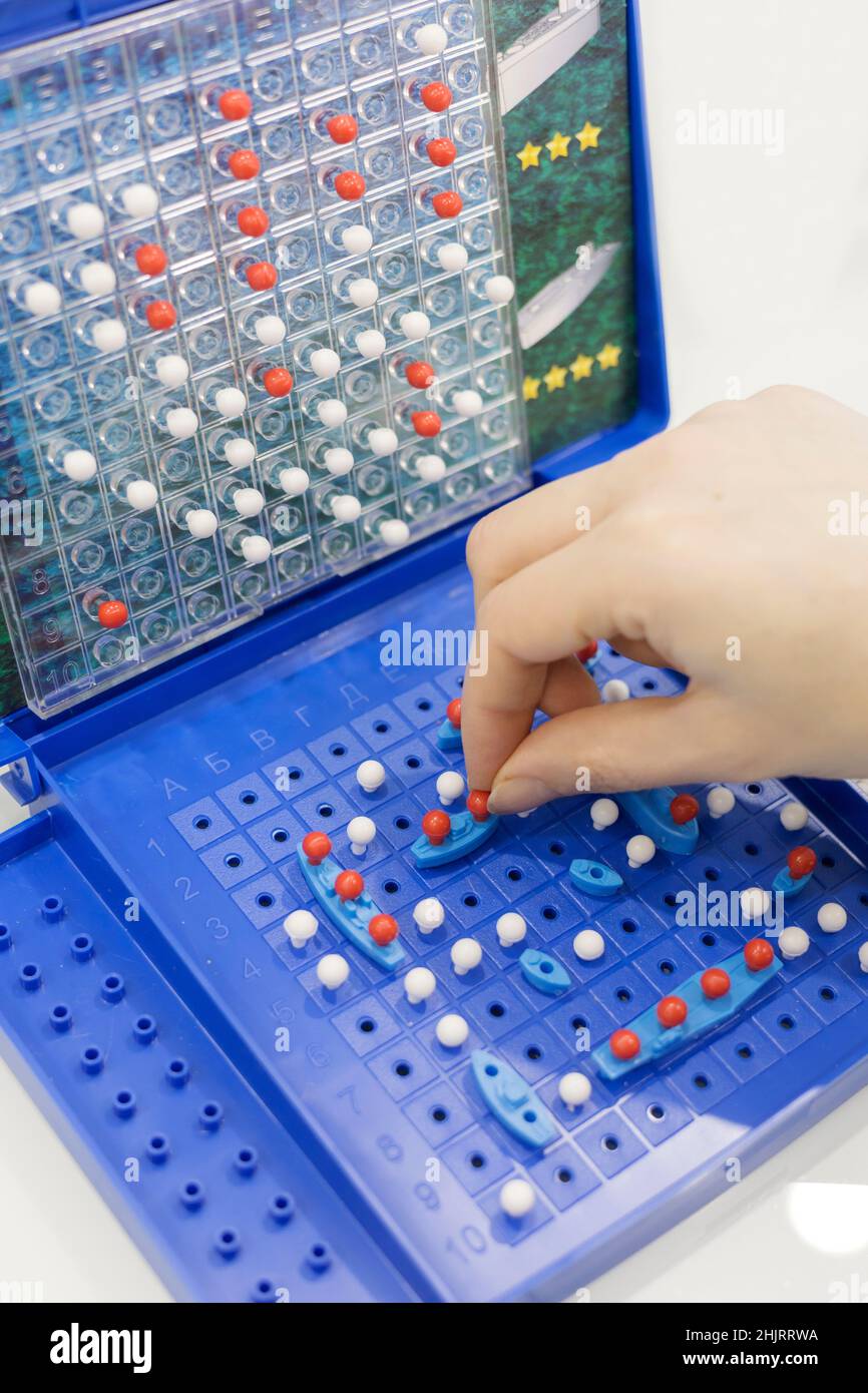 Nahaufnahme von Game-Sea Battle. Spielzeugkriegschiffe und U-Boot werden auf dem Spielfeld platziert. Konzept-Strategie, Denken, Sieg, Niederlage. Stockfoto