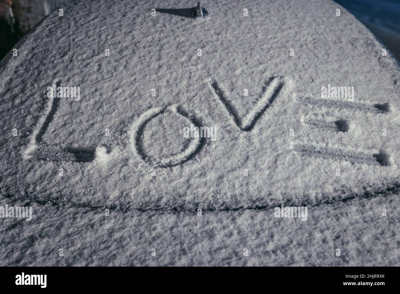 Wort Liebe geschrieben auf einem Auto mit Schnee bedeckt Stockfoto