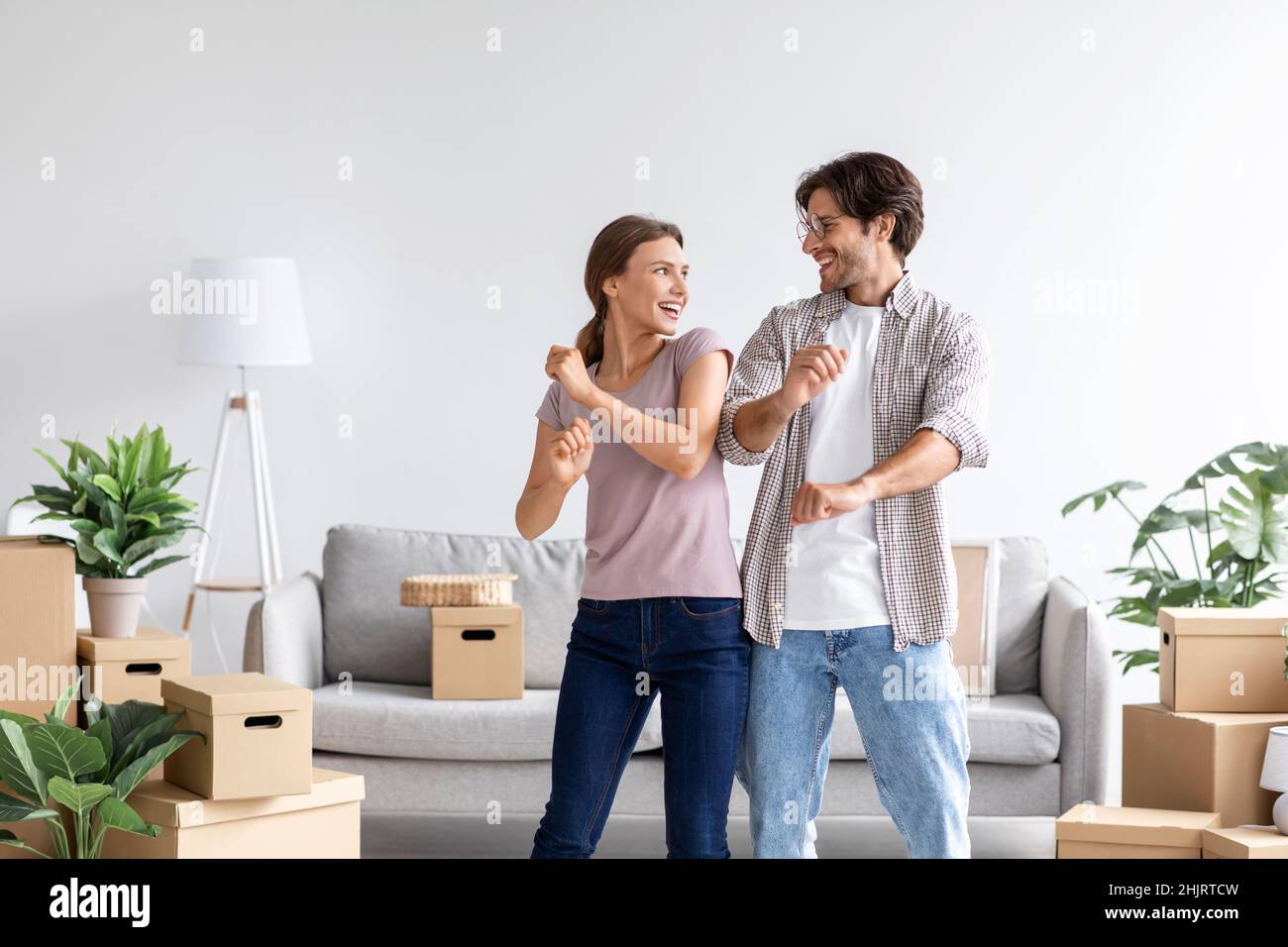 Glücklich zufrieden kaukasischen Mann und Frau feiern Kauf einer neuen Wohnung, tanzen im Zimmer Interieur Stockfoto