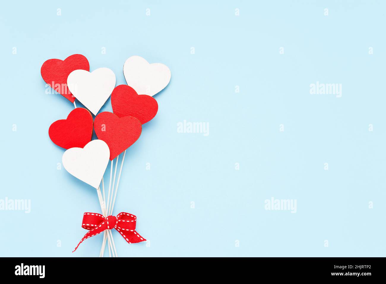 Valentinstag Hintergrund. Rote und weiße Holzherzen auf hellblauem Hintergrund. Festliche Weihnachtskarte. Flach liegend, Platz für Text kopieren Stockfoto