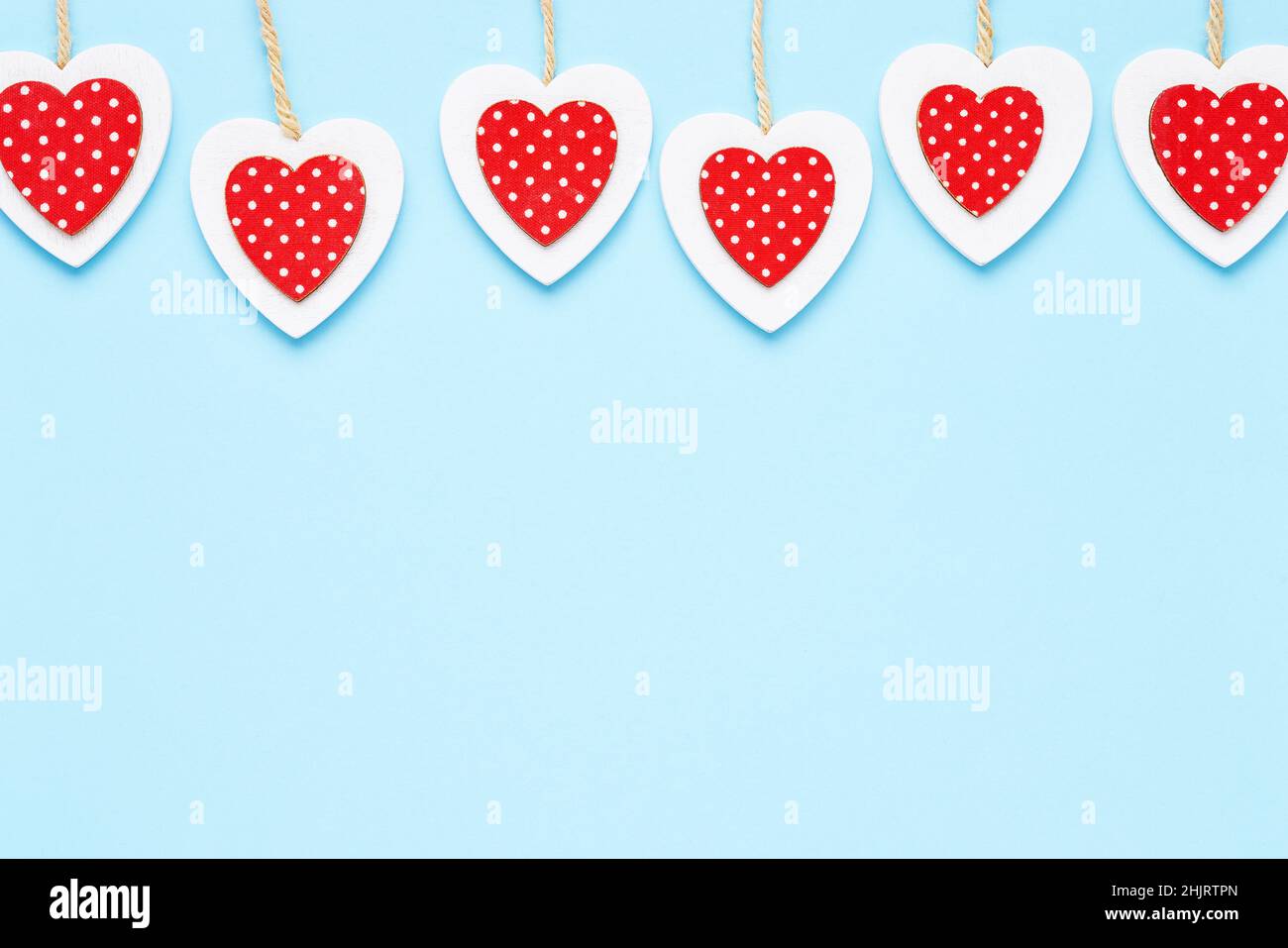 Valentinstag Hintergrund. Rot-weiße Holzherzen vor hellblauem Hintergrund. Flach liegend, Platz für Text kopieren Stockfoto