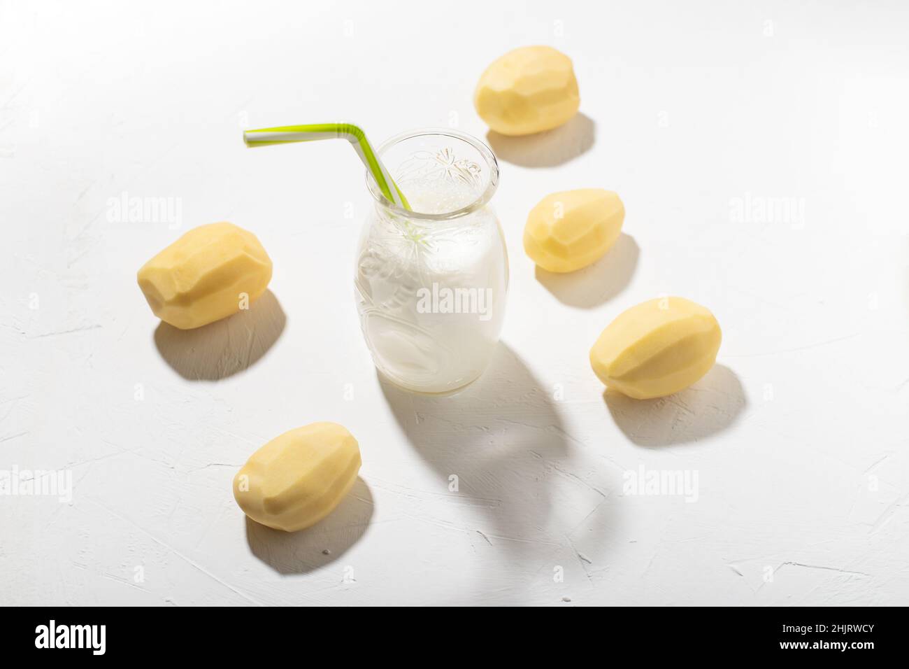 Kartoffelmilch-Konzept. Flasche mit Kartoffelmilch auf weißem Hintergrund. Eine Alternative zu tierischen Produkten. Vegane Küche. Stockfoto