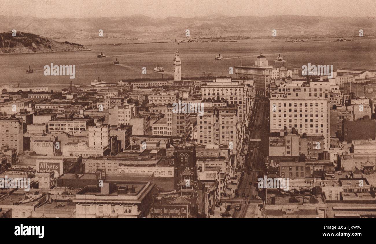 Auf der linken Seite befindet sich ein Teil von Goat Island und auf der anderen Seite des Wassers sehen Sie die Gebäude von Oakland & Berkeley. San Francisco (1923) Stockfoto