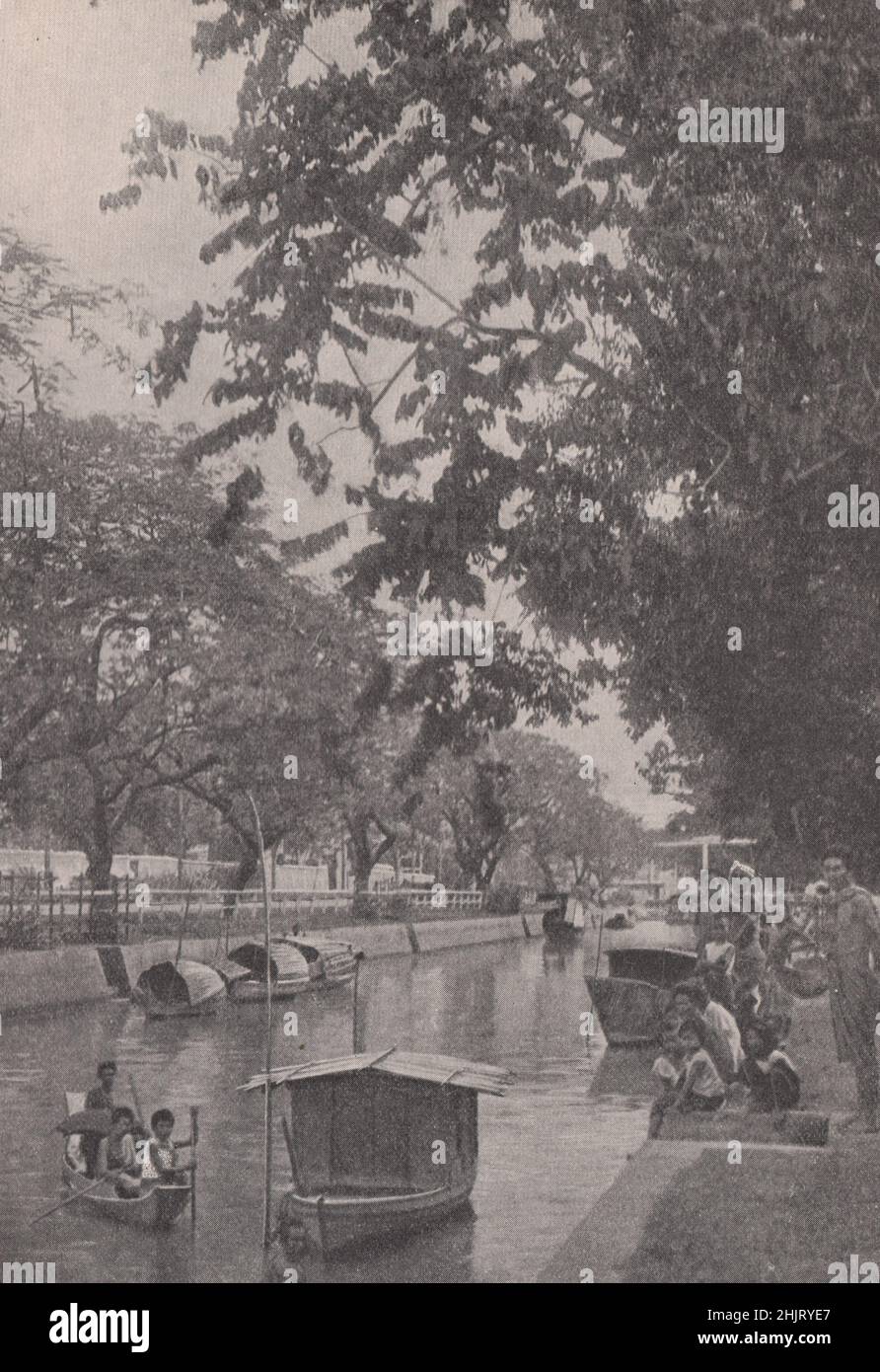 Moderner Kanal, der von sattem Laub in der Hauptstadt gesäumt ist. Thailand. Siam (1923) Stockfoto