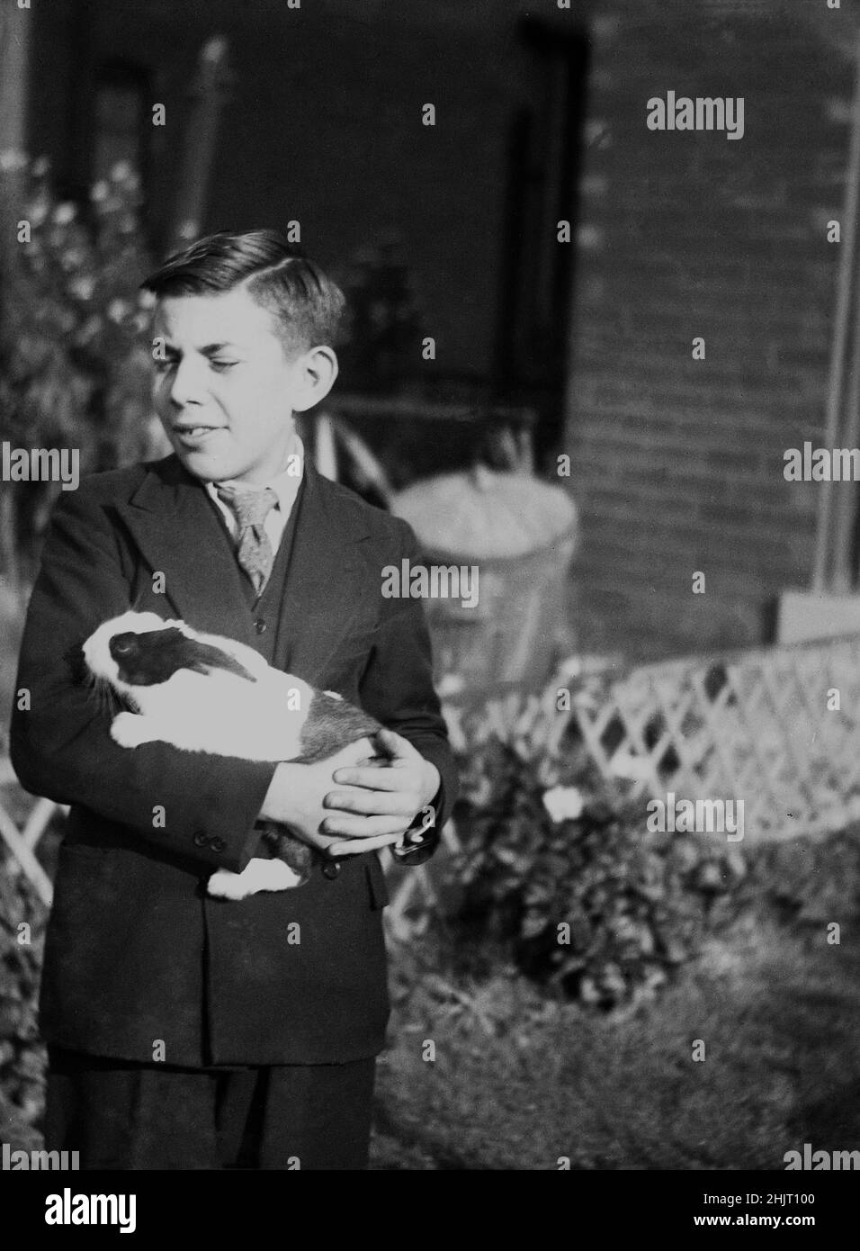 1940s, historisch, ein Teenager-Junge in doppelreihiger Anzugkleidung, der draußen mit seinem Meerschweinchen stand, Dudley, Warwick, England, Großbritannien. Ursprünglich aus Südamerika wurden Guinea-Schweine nach Europa gebracht und sind seit dem 1800s beliebte Haustiere. Stockfoto