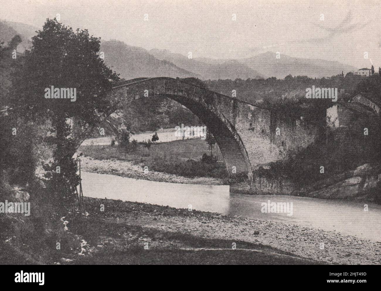Ein Apennin-Bach, eingerahmt vom Bogen einer alten Brücke. Italien. Toskana (1923) Stockfoto
