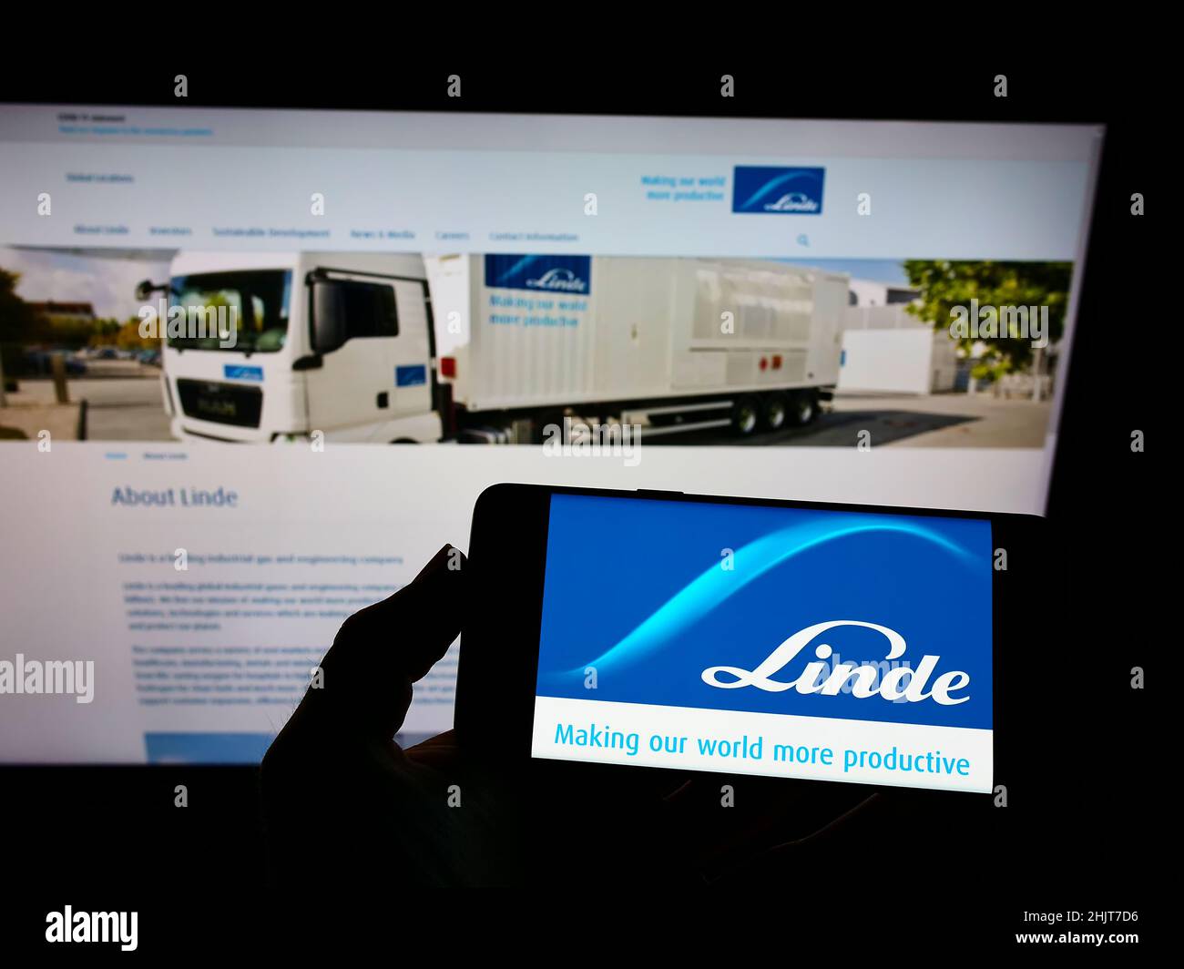 Person, die ein Smartphone mit dem Logo des Chemieunternehmens Linde plc auf dem Bildschirm vor der Website hält. Konzentrieren Sie sich auf die Telefonanzeige. Stockfoto