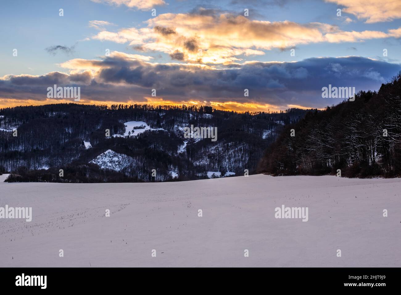 Winterlandschaft mit Berg und Wald bei Sonnenuntergang. Schöne bunte brennende Wolken. Natur Hintergrund, Tapete. Schutzgebiet Vrsatec, Slowakei Stockfoto