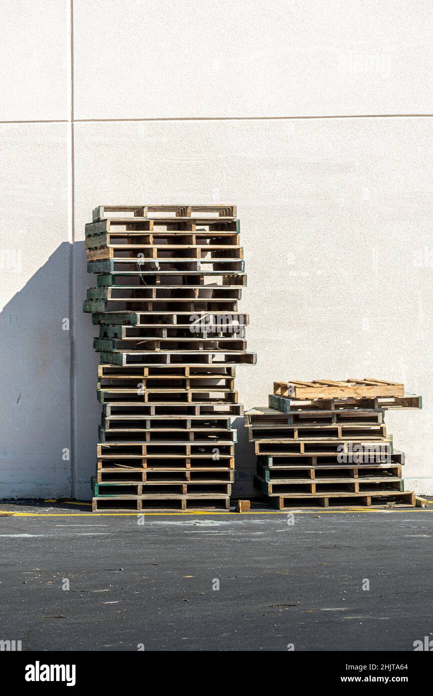 Vertikale Aufnahme eines Stapels leerer Holzpaletten gegen die Wand. Stockfoto