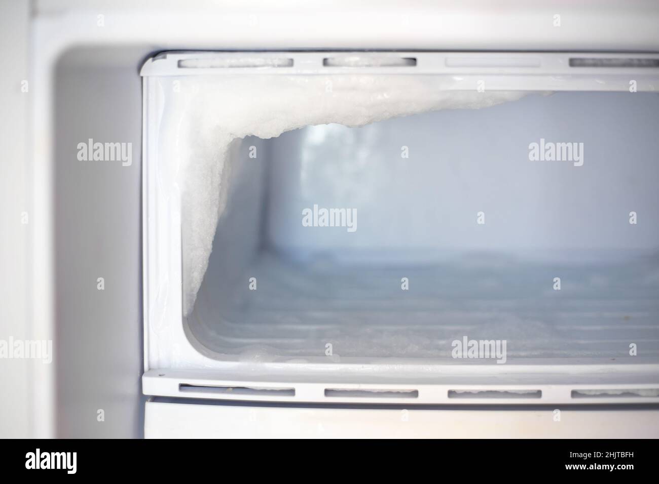 Kühlschrank mit Gefrierfach und gefrorenem Eis. Wartung und Abtauen des Kühlschranks. Stockfoto