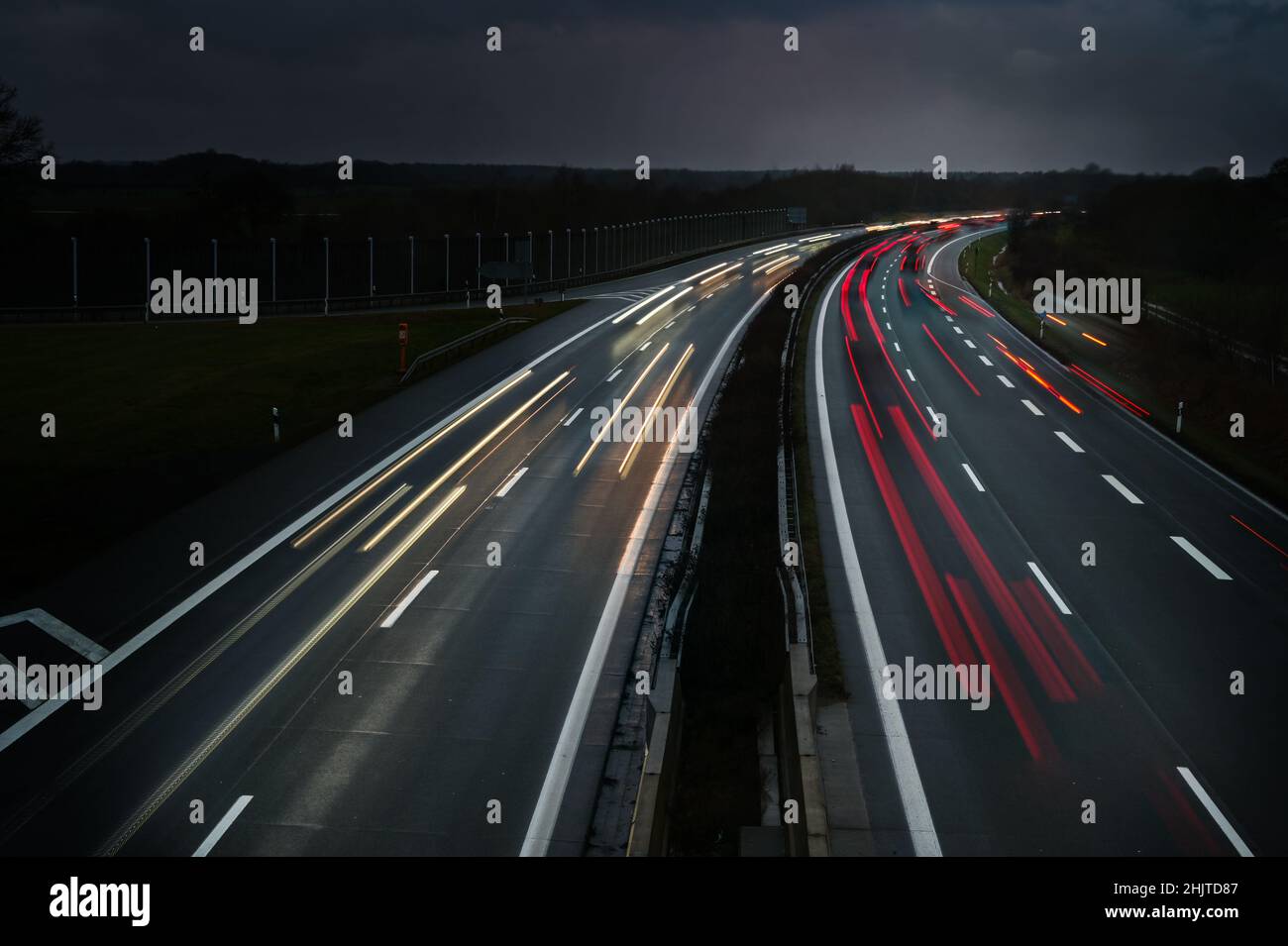 Lichter fahrenden Autos auf einer Autobahn bei Nacht in Deutschland, lange Belichtung mit Bewegungsunschärfe, Kopierbereich, ausgewählter Fokus Stockfoto
