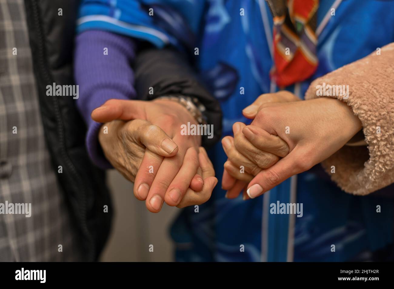 Die Großmutter hält die Hände eines jungen Mannes und einer Frau. Nahaufnahme. Alte Hände. Stockfoto