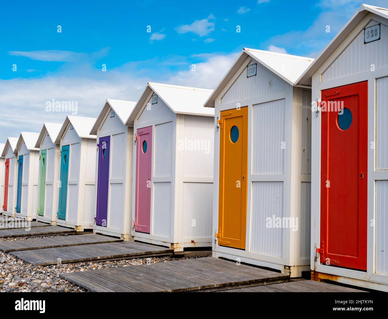 Reihe traditioneller Badehütten mit pastellfarbenen Türen am Strand Le Treport, Normandie, Frankreich Stockfoto