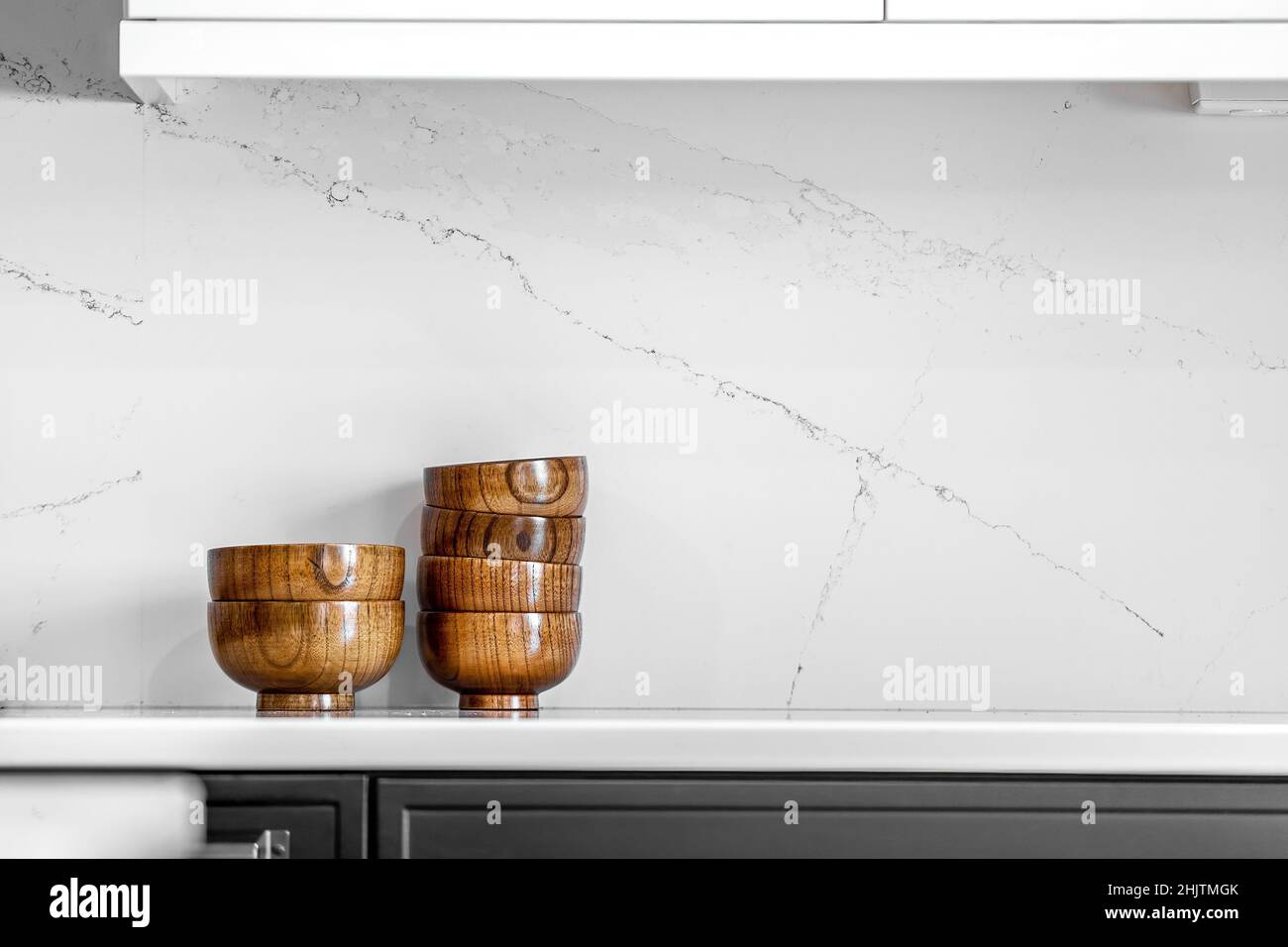 Moderne Küche und Esszimmer im mittleren Jahrhundert mit schwarzen Schränken, weißen Schränken, weißen Quarz- und Walnussakzenten Stockfoto
