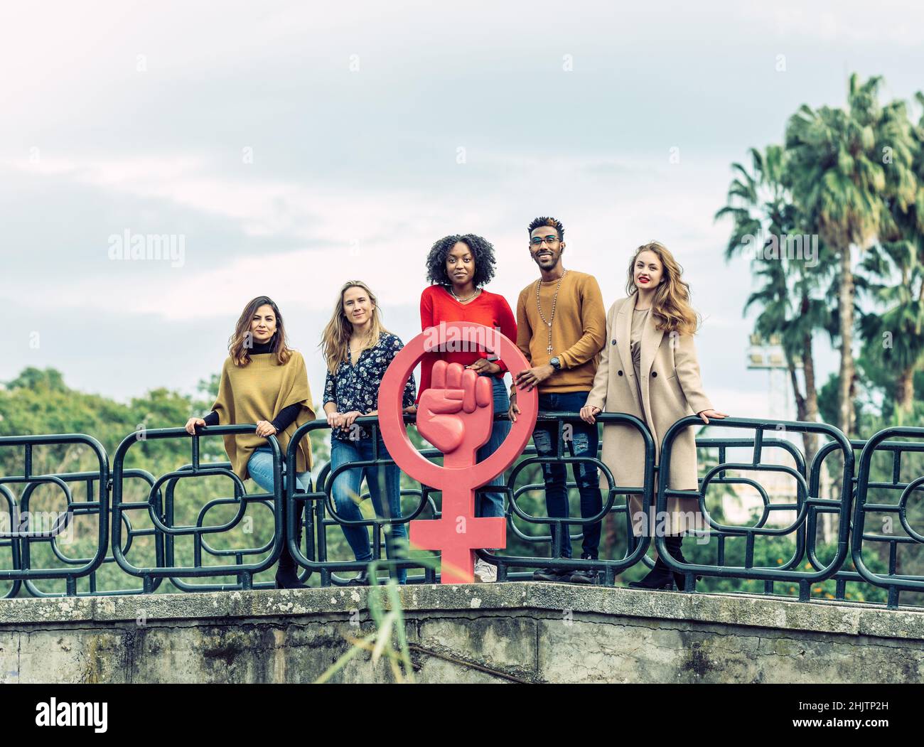 Eine interracial Gruppe von 5 Personen hält ein feministisches Korksymbol hoch Stockfoto