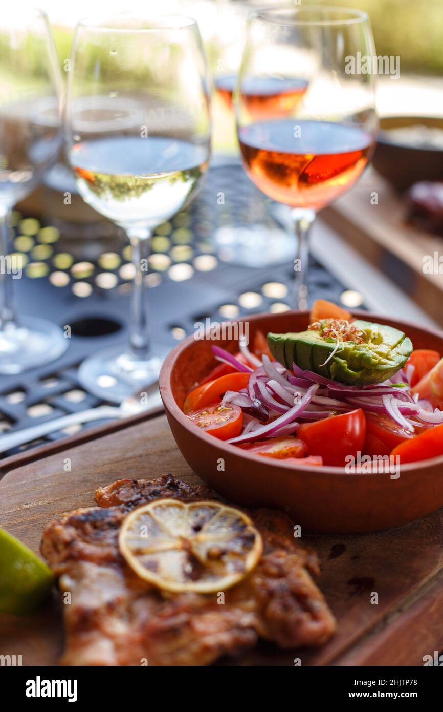 Teller mit Gemüsesalat und Gläsern Wein auf dem Tisch Stockfoto