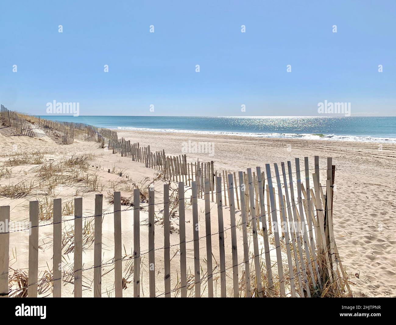 Sonniger Tag am Strand mit umzäunten Dünen, East Hampton, NY, USA Stockfoto