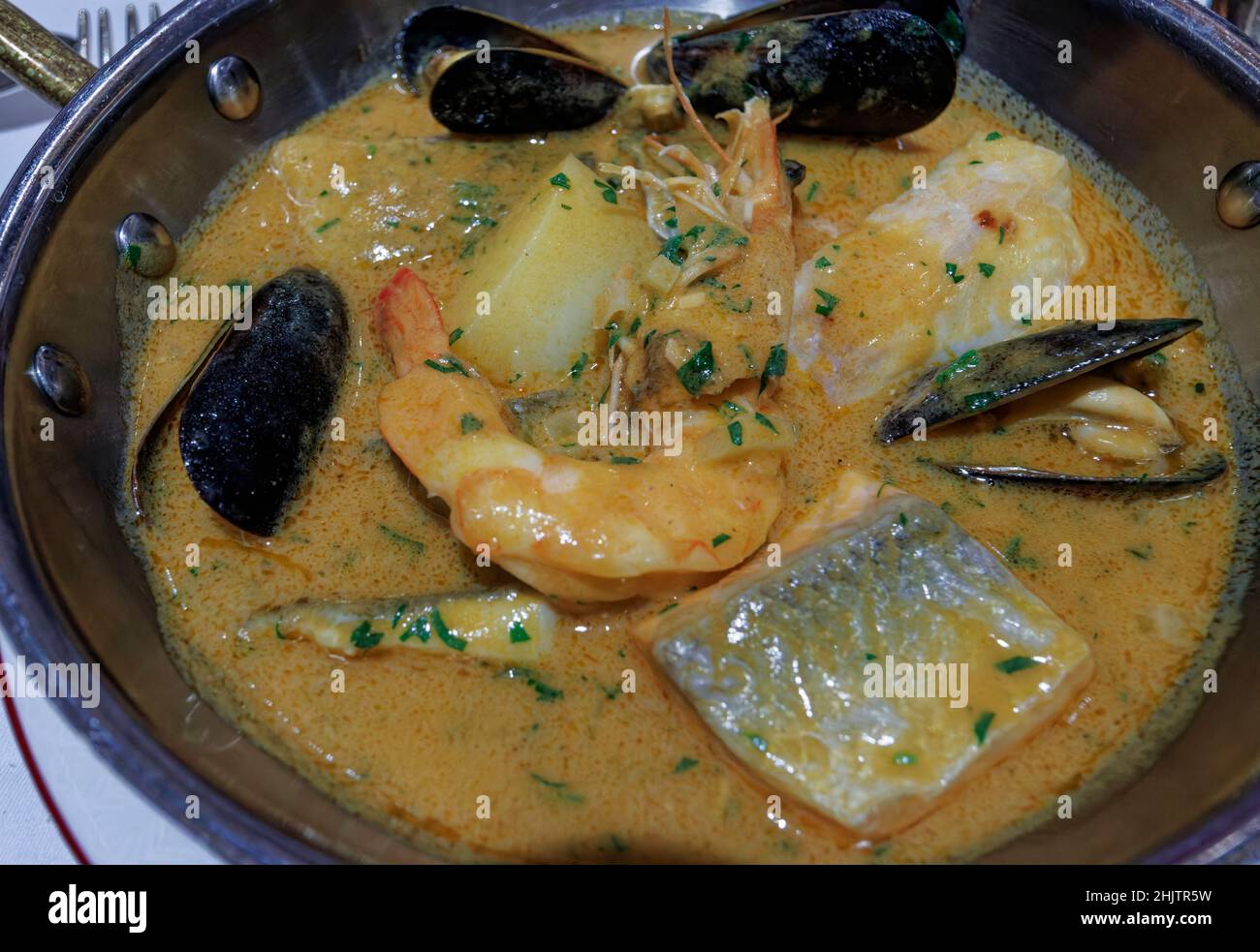 Fischeintopf, der in einer Pfanne oder Bouillabaisse serviert wird, ein traditionelles, köstliches Suppengericht mit Meeresfrüchten und Garnelen, Muscheln und frischen Fischstücken Stockfoto