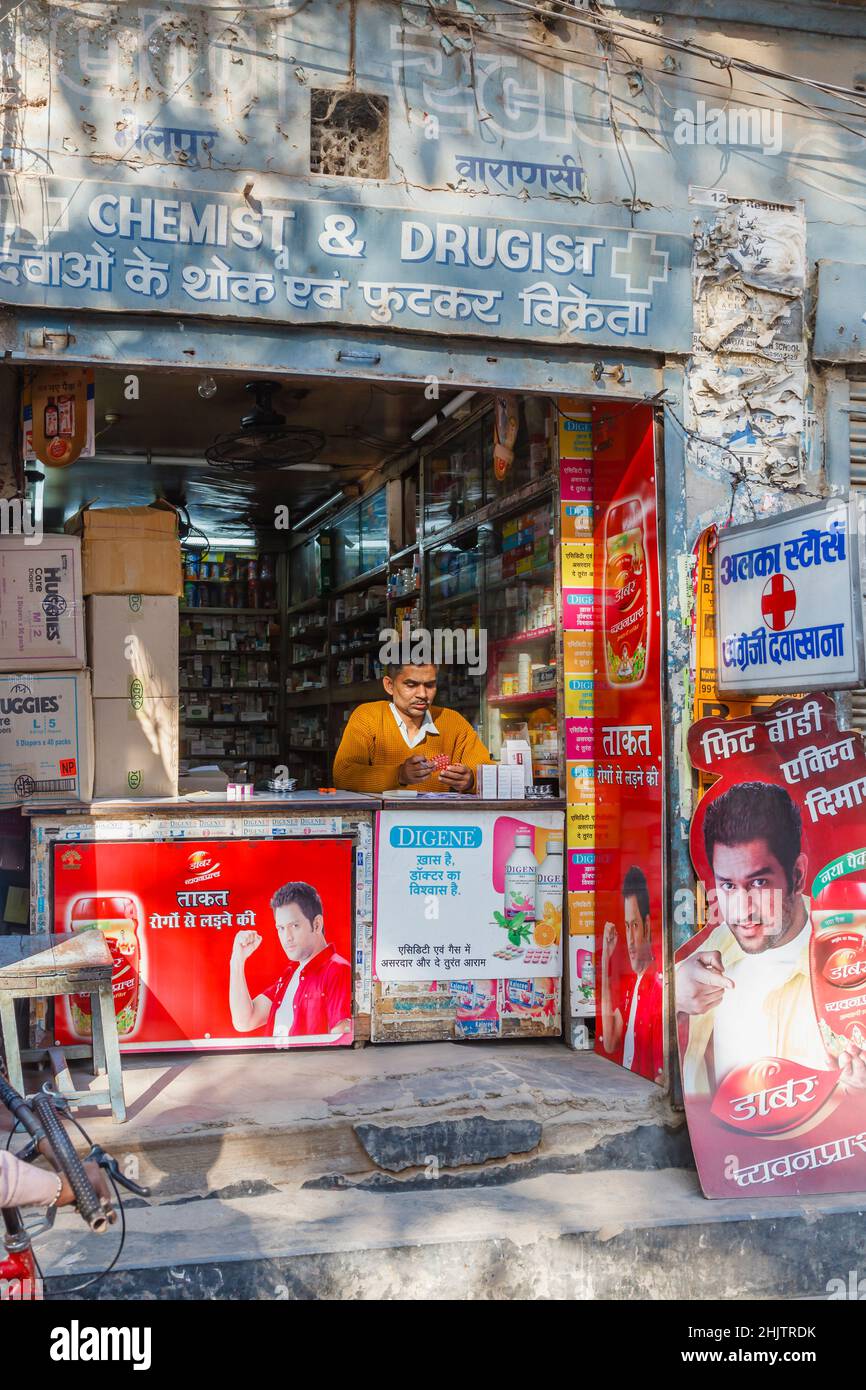 Ein typischer kleiner Kiosk am Straßenrand und ein Ladenbesitzer am Straßenrand in Varanasi, einer Stadt am Fluss Ganges in Uttar Pradesh, Nordindien Stockfoto