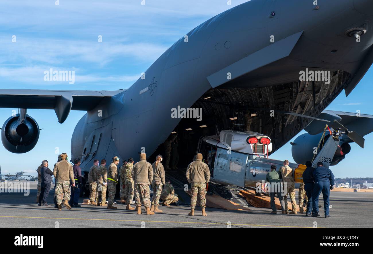 Yokota Airmen und Vertragspartner laden einen UH-1N Twin Huey Hubschrauber, der dem 459th Airlift Squadron zugewiesen wurde, in ein C-17 Globemaster III Flugzeug auf dem Yokota Air Base, Japan, zur Unterstützung von Cope North 2022. Die jährliche Übung soll die Zusammenarbeit zwischen dem US-Militär, der Royal Australian Air Force und der Japan Air Self-Defense Force verbessern und die Sicherheitskooperation und Stabilität in der Indo-Pazifik-Region verbessern. (USA Foto der Luftwaffe von Staff Sgt. Braden Anderson) Stockfoto