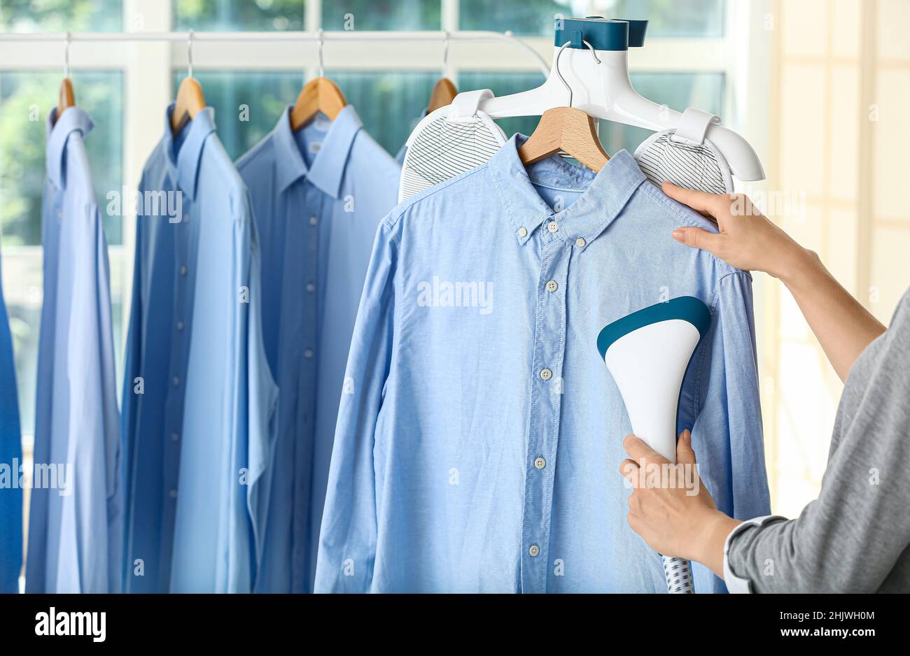 Frau bügelt Hemd mit Dampf bei der Trockenreinigung Stockfotografie - Alamy