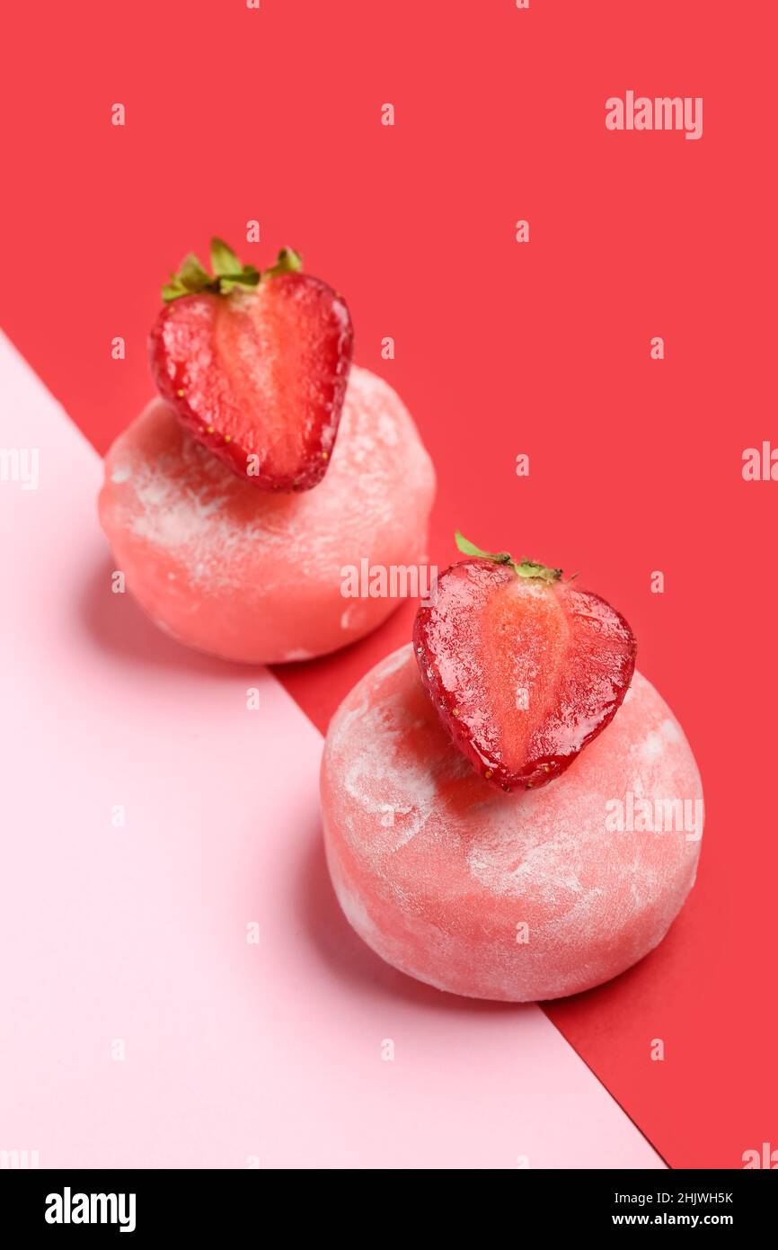 Leckere Mochi, Erdbeere und Essstäbchen auf farbigem Hintergrund Stockfoto