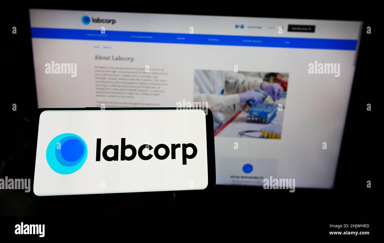 Person, die das Smartphone mit dem Logo des US-Laborunternehmens LabCorp auf dem Bildschirm vor der Website hält. Konzentrieren Sie sich auf die Telefonanzeige. Stockfoto