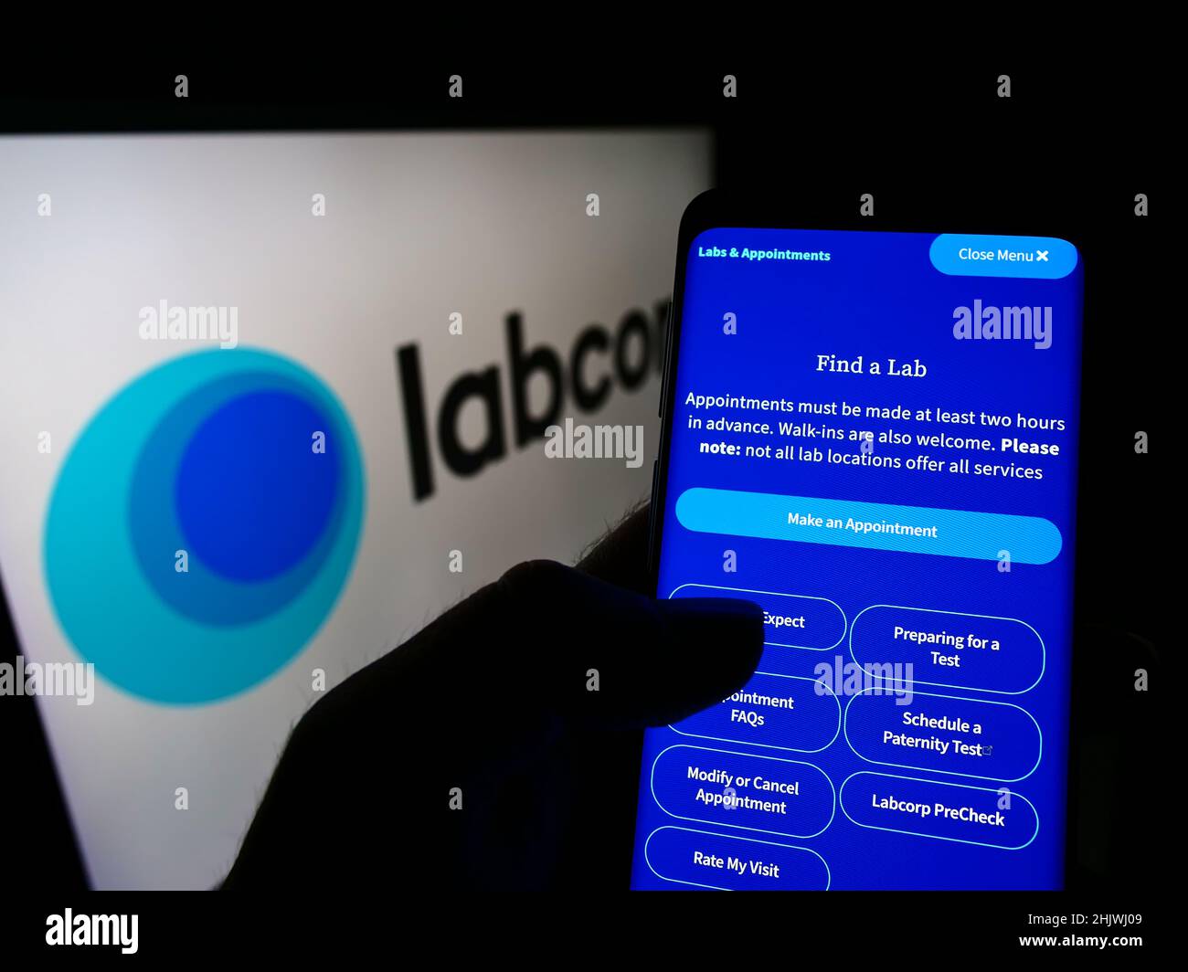 Person, die Mobiltelefon mit der Webseite des US-Laborunternehmens LabCorp auf dem Bildschirm vor dem Unternehmenslogo hält. Konzentrieren Sie sich auf die Mitte des Telefondisplays. Stockfoto
